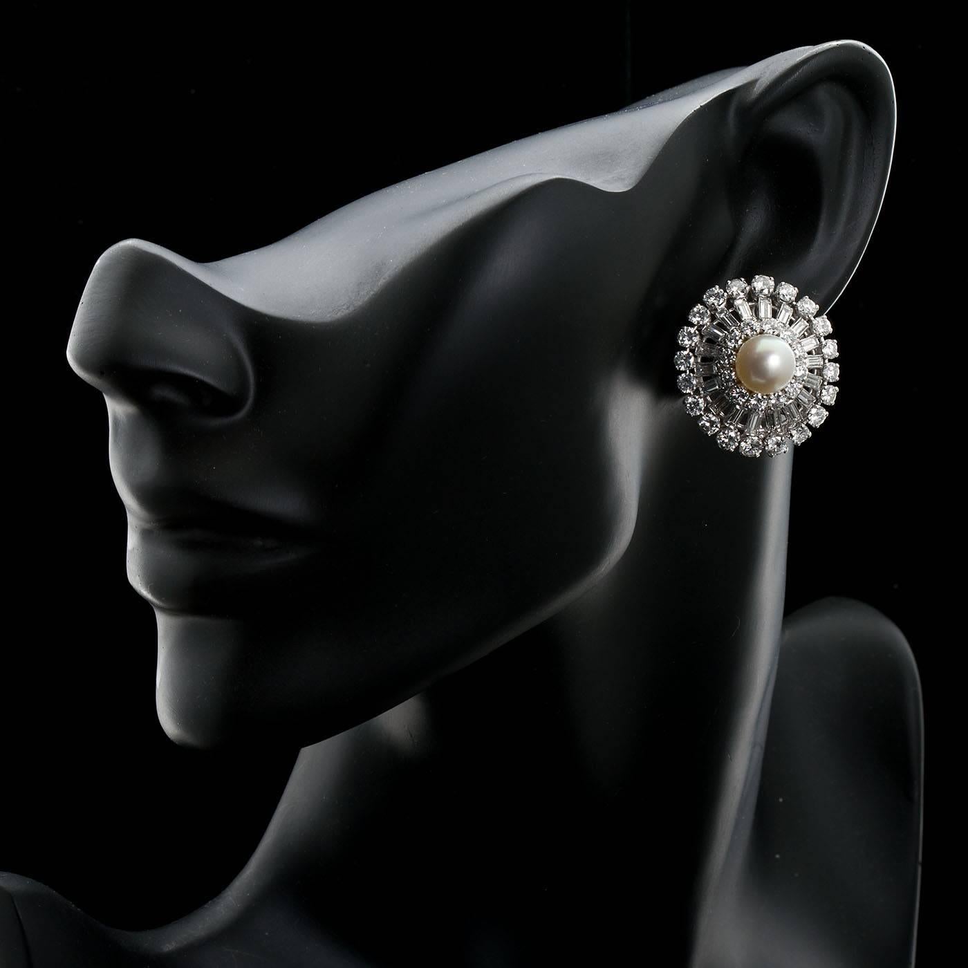 Une paire de clips d'oreilles en platine, ornés de diamants et de perles.  La perle centrale mesure 9 mm. Deux cercles de diamants ronds de taille brillant et un cercle central de diamants de forme baguette. 
Les diamants sont de collection/de très