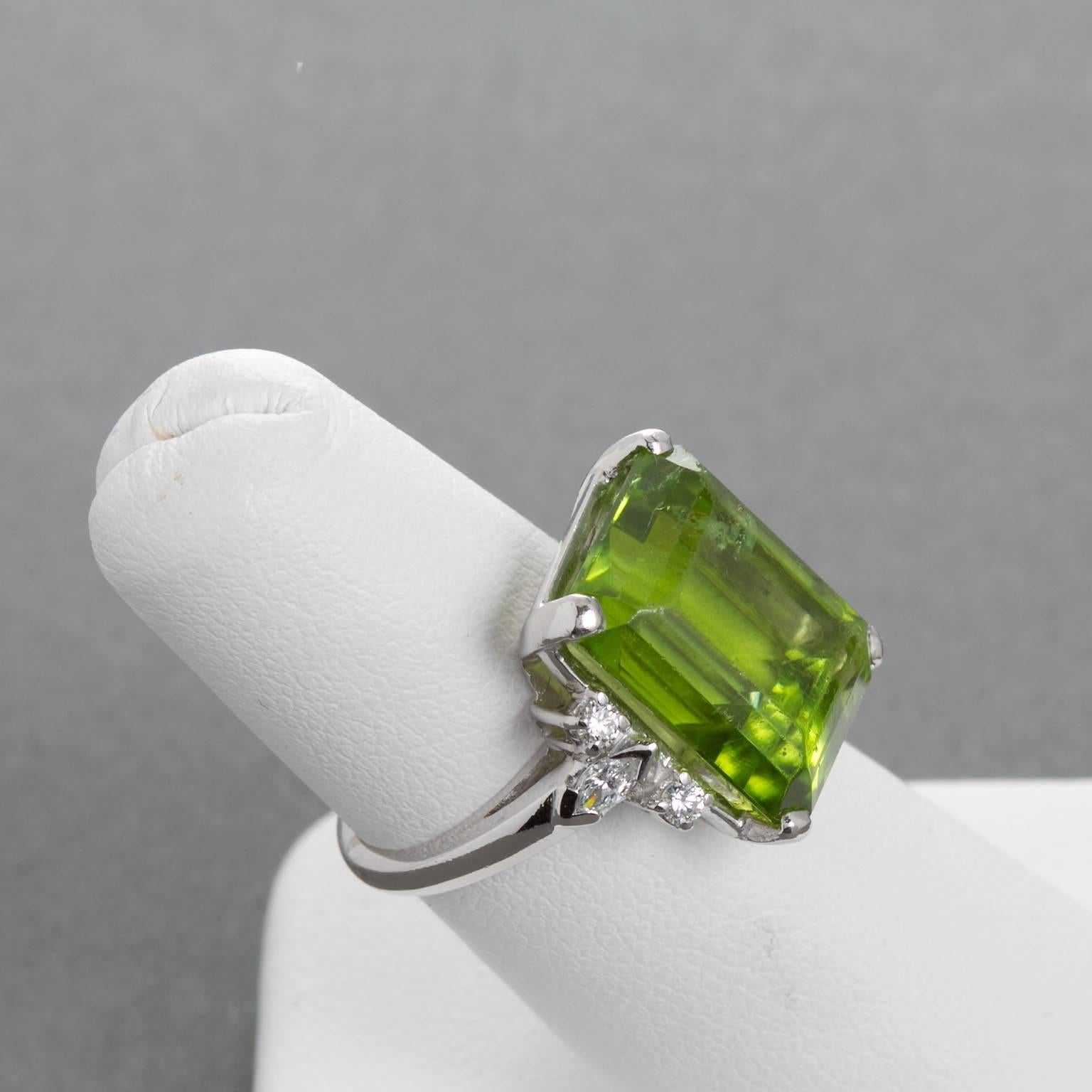 A large approx. 10.70 ct olive green emerald cut peridot set in a diamond and platinum ring. Two marquise shaped diamonds and four round brilliant diamonds, 0.40 ctw. Ring custom sized to fit.
Periodot dimensions: 14.60 x 11.50 x 8.70 mm

No. 6663