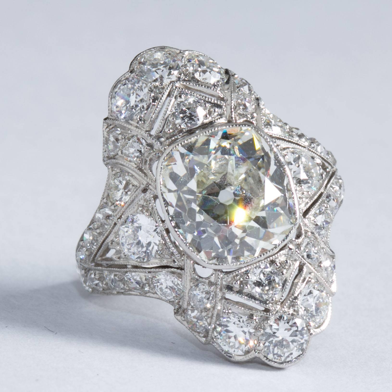 A very fine original navetté style Art Deco ring inlaid with fine diamonds and filigree edging set with a rare center antique cushion cut diamond weighing approximately 4.60 carats.
Diamond is graded according to the Gemological Institute of America