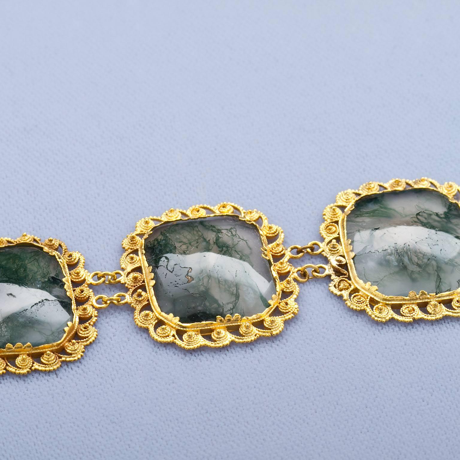 A unique gold and moss agate link bracelet contains six moss agate panels set in filgree and beaded yellow gold. Circa 1820.  In custom leather and silk case stamped on the interior Watherston &; Son,  12 Pallmott East, London

No. 2436