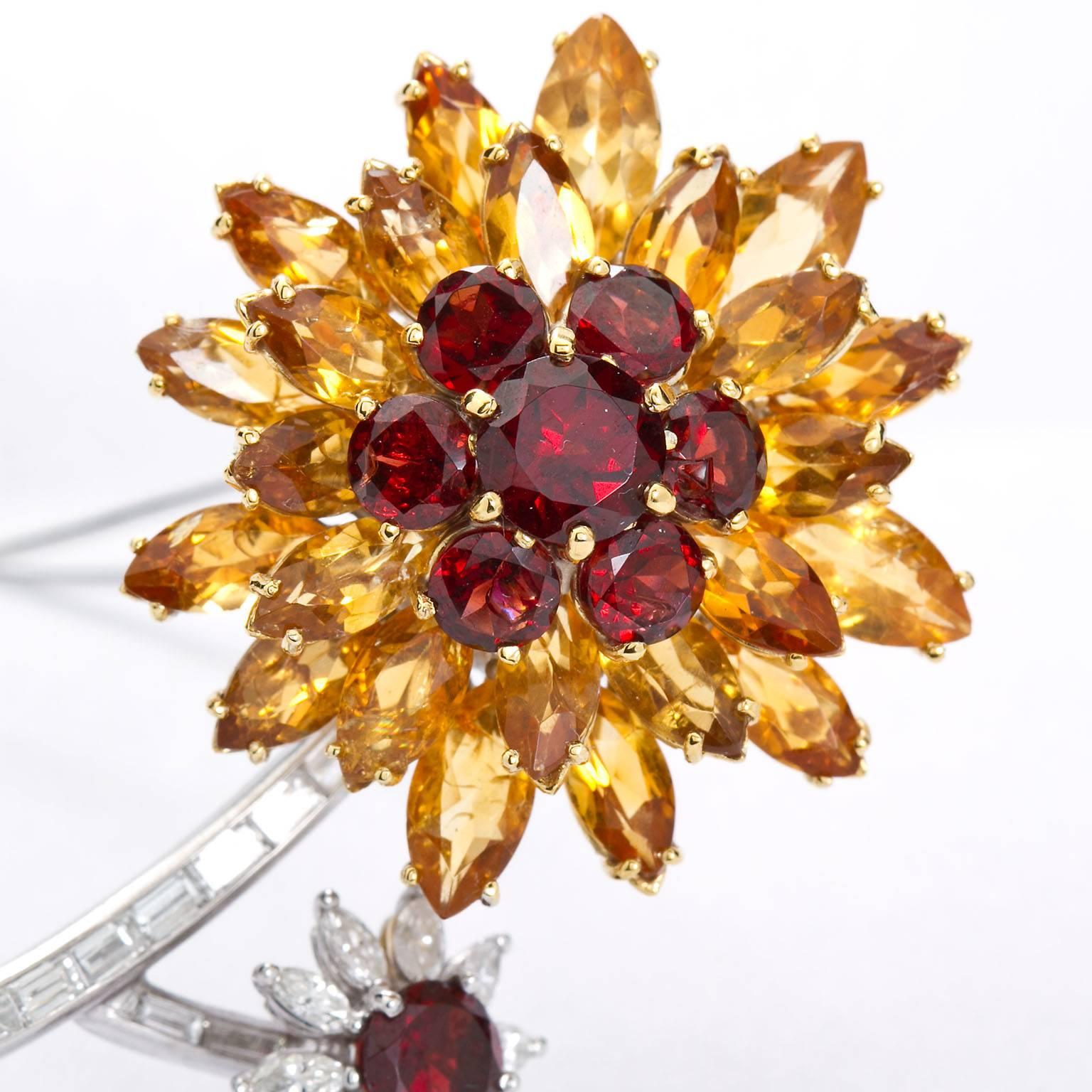 A hand crafted diamond and garnet flower brooch contains approx. 35 carats of amber and red garnets set in platinum with calibrated baguette shaped and marquise shaped diamonds approx. 4.60 ctw. 

Measures: 2.75 inches by 1.5 inches.

No. 7632