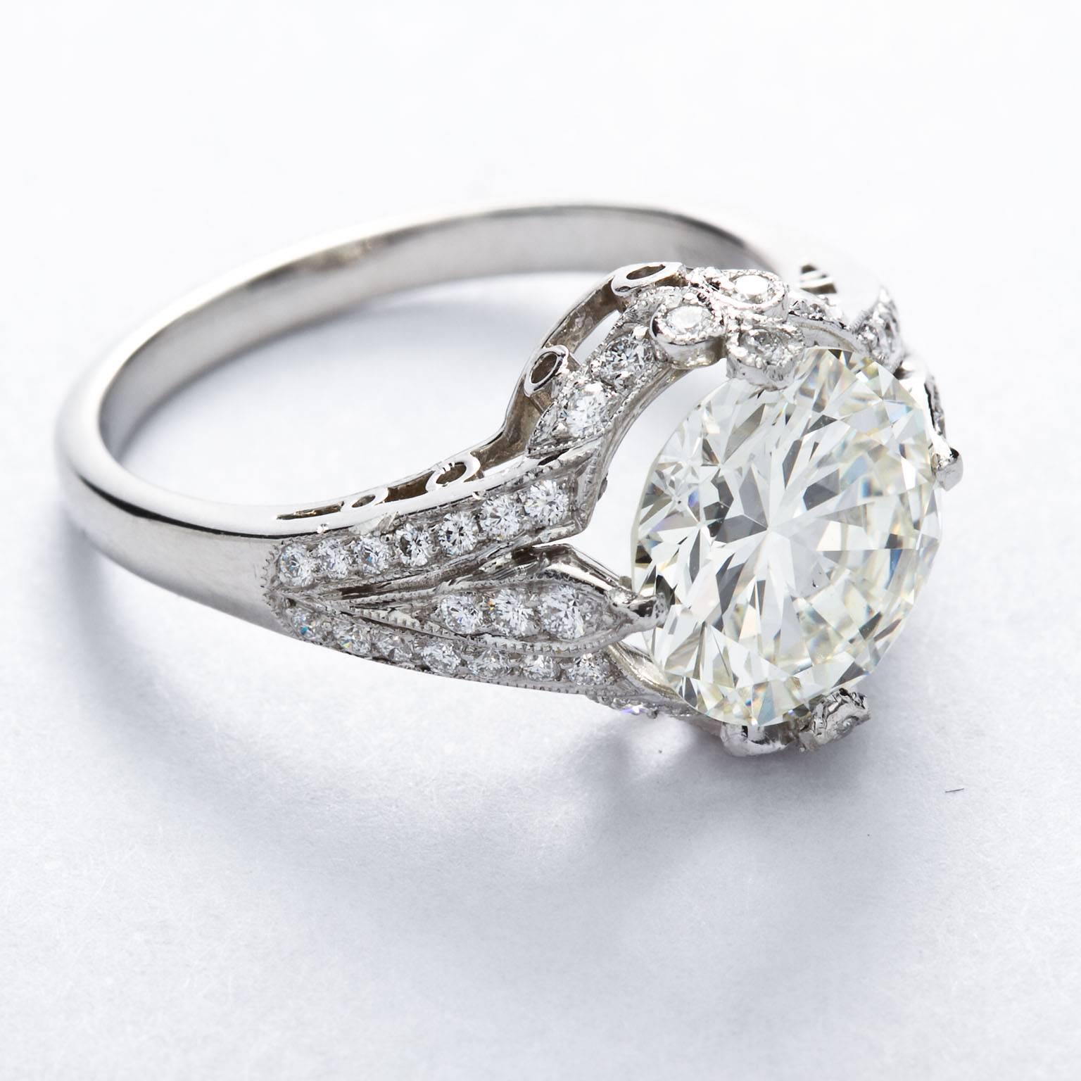 A two carat diamond set in a platinum and diamond ring with delicate millgraining and filigree work.  Ring size 6 (resizable from 3-10).

No. M7714
