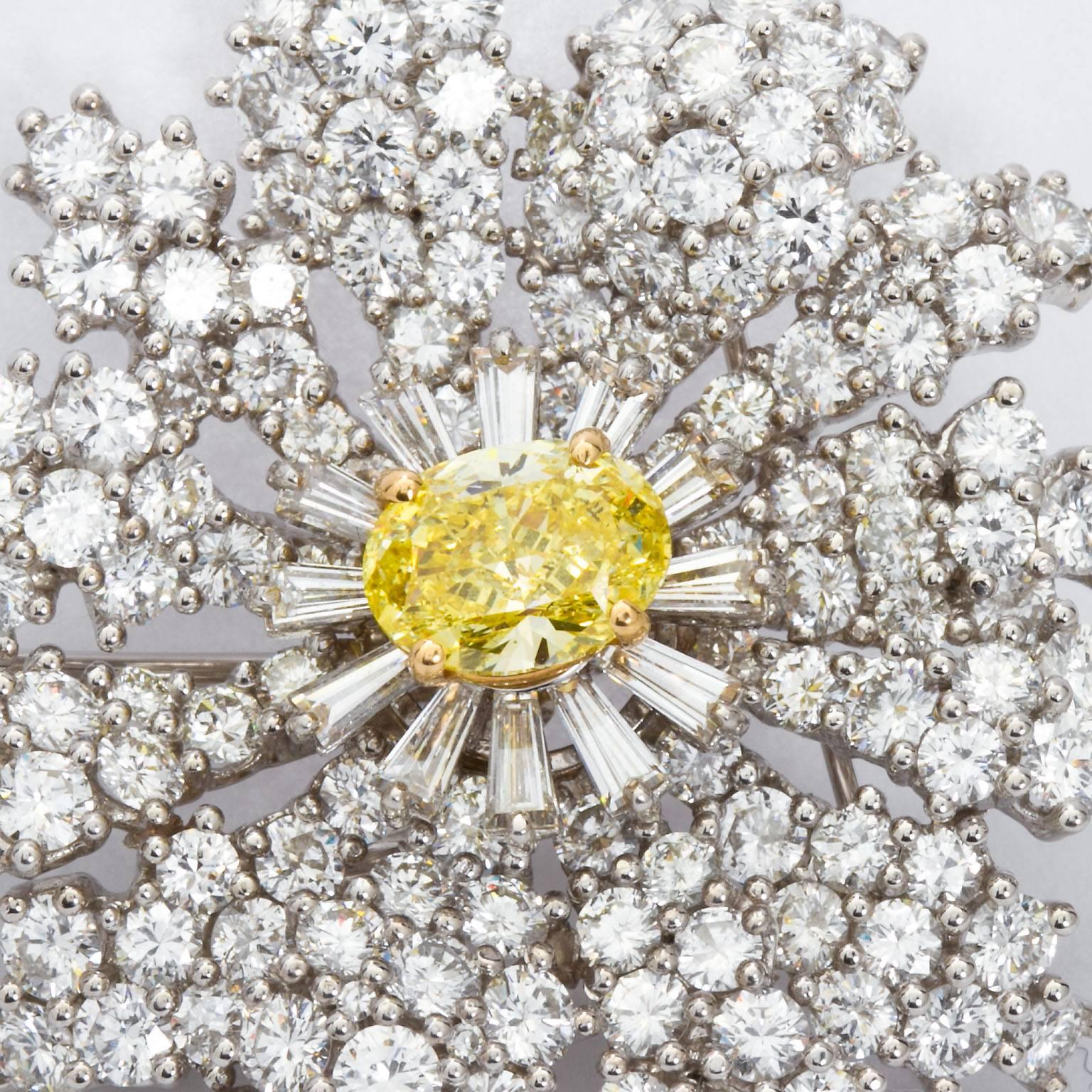 Brooch the subject! A very impressive diamond in platinum flower brooch set with over 20 carats of high quality diamonds and graced with a center approx. 2.00 carats fancy intense yellow oval cut diamond.  Brooch contains round brilliant, calibrated