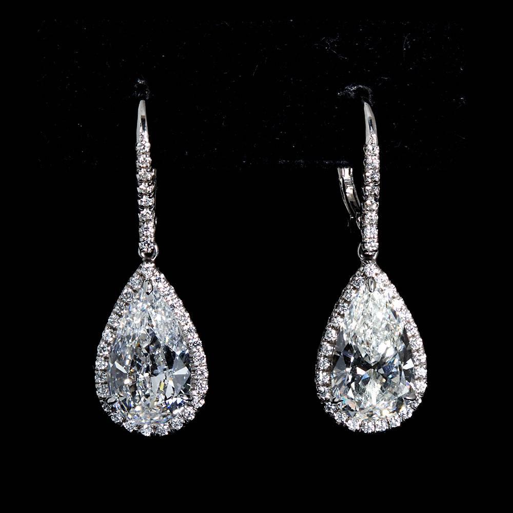 A very fine pair of F-G color SI1-2 clarity pear shaped diamond pendant earrings. Total carat weight 5.29. Set in platinum halo style pave diamond borders with leverbacks.
Measures 1-1/4
