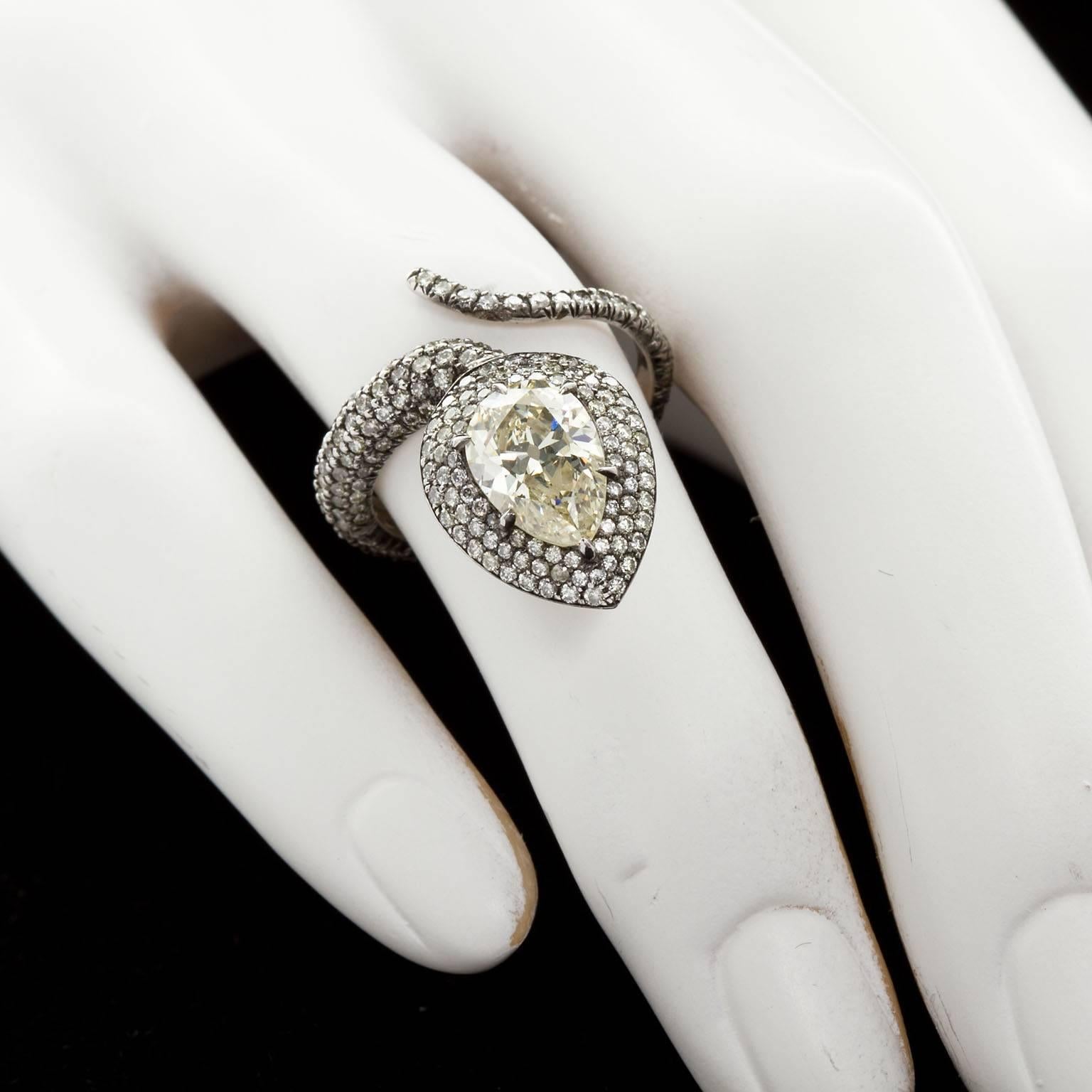 A fanciful diamond in black rhodium platinum snake ring . The center stone is an approx. 1.75 ct pear shape diamond set in a pave diamond set ring formed as the snake body with winding tail.  Approx. 1.25 ctw of diamond melee. Ring size 6.

No. 7843