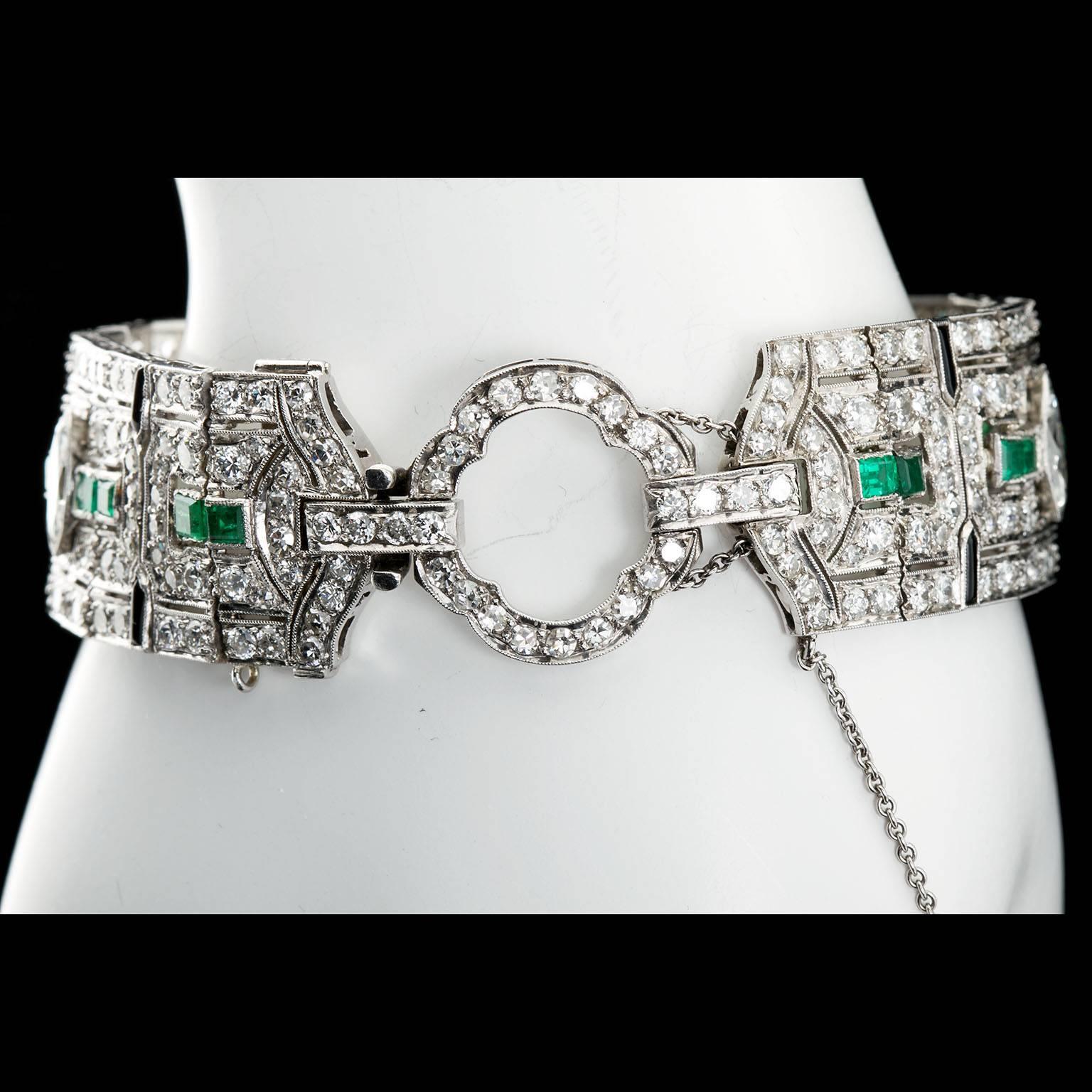 A magnificent Art Deco five marquise shape diamond and round-cut diamond platinum bracelet with emerald and onyx accents. The clasp is in the form of a diamond set buckle. Square step cut emeralds run down the center line of the bracelet with fine