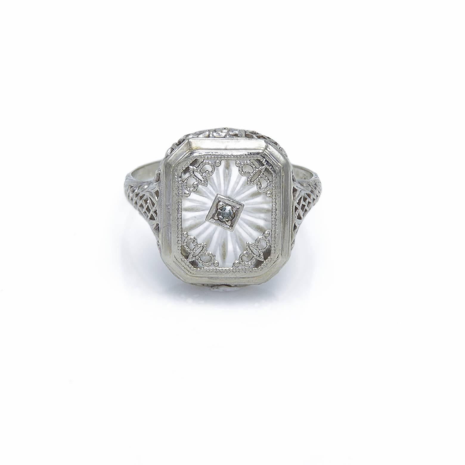 This gorgeous and detailed diamond ring has a beautiful backdrop of a ray crystal star burst in the backround. The hand detailed intricate filigree bezel is clearly exquisite with flowers in the design and looks as if it were found in the best