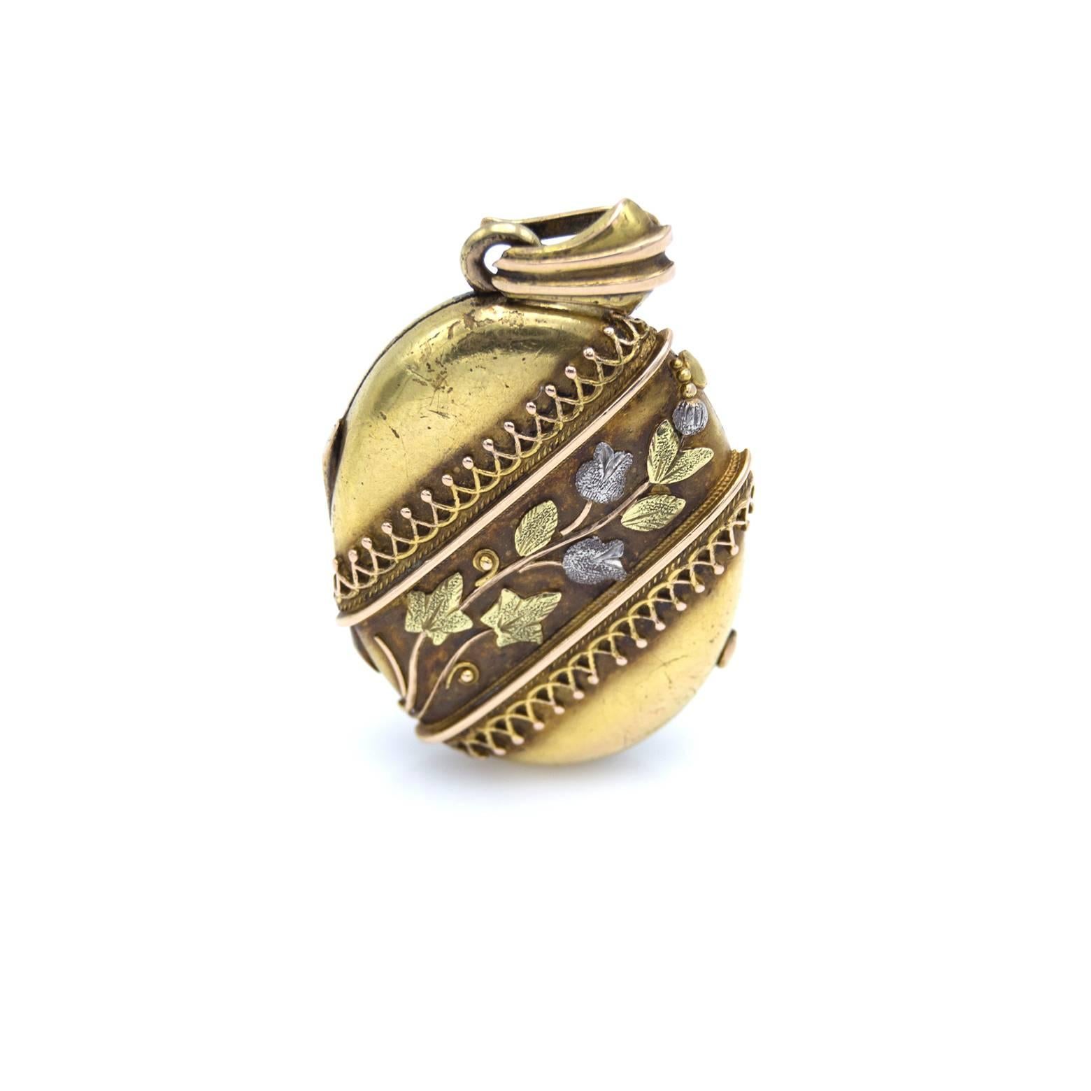 This antique locket is adorned with flowers and leaves in many shades of gold and the romance of this piece is timeless. Green gold, rose gold, platinum and yellow gold create this masterpiece. The flowers and leaves dance with spirals as if  being