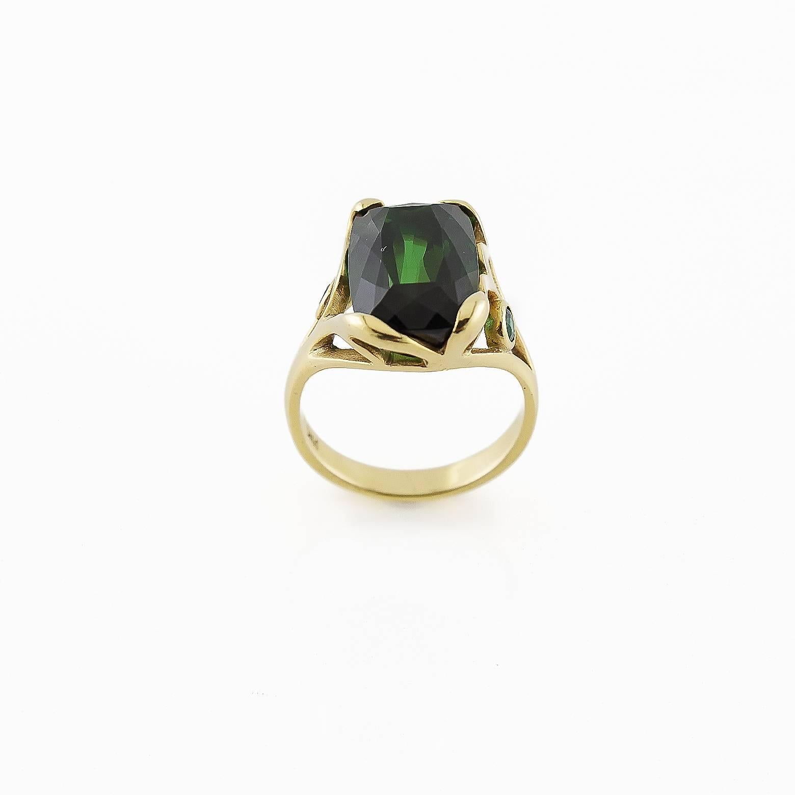 This luscious over 6 carat deep green tourmaline is set in 18k gold and accented with two round tourmalines, This ring is stunning and very comfortable to wear.The warmth and clarity of the stone is exceptional. A truly amazing ring!! It is a size 7.