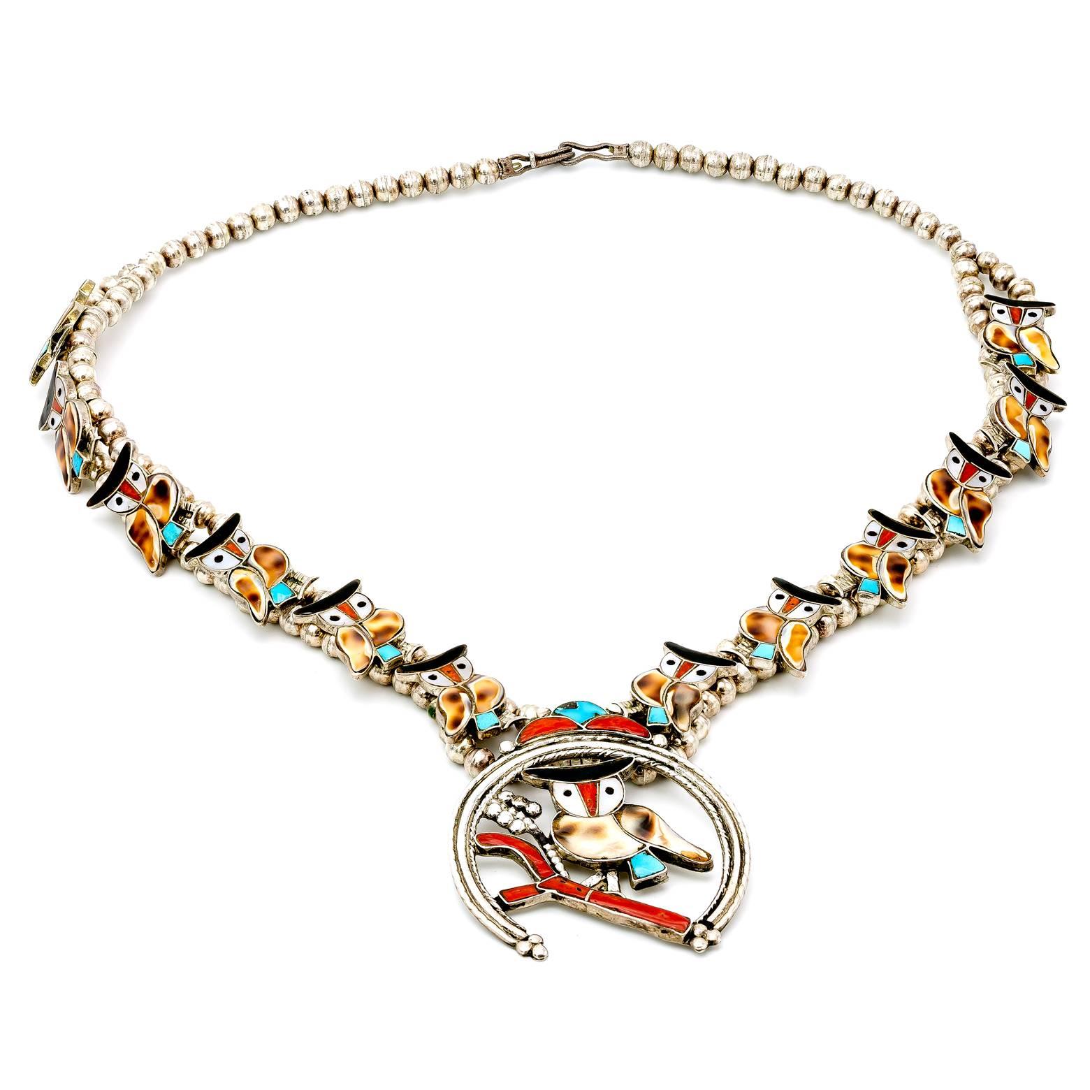 Vintage e fatta a mano, questa splendida collana in stile fiore di zucca è incastonata con madreperla, turchese, corallo e conchiglia. Un grande oggetto da collezione per gli amanti dei gioielli Zuni e dei gufi. 