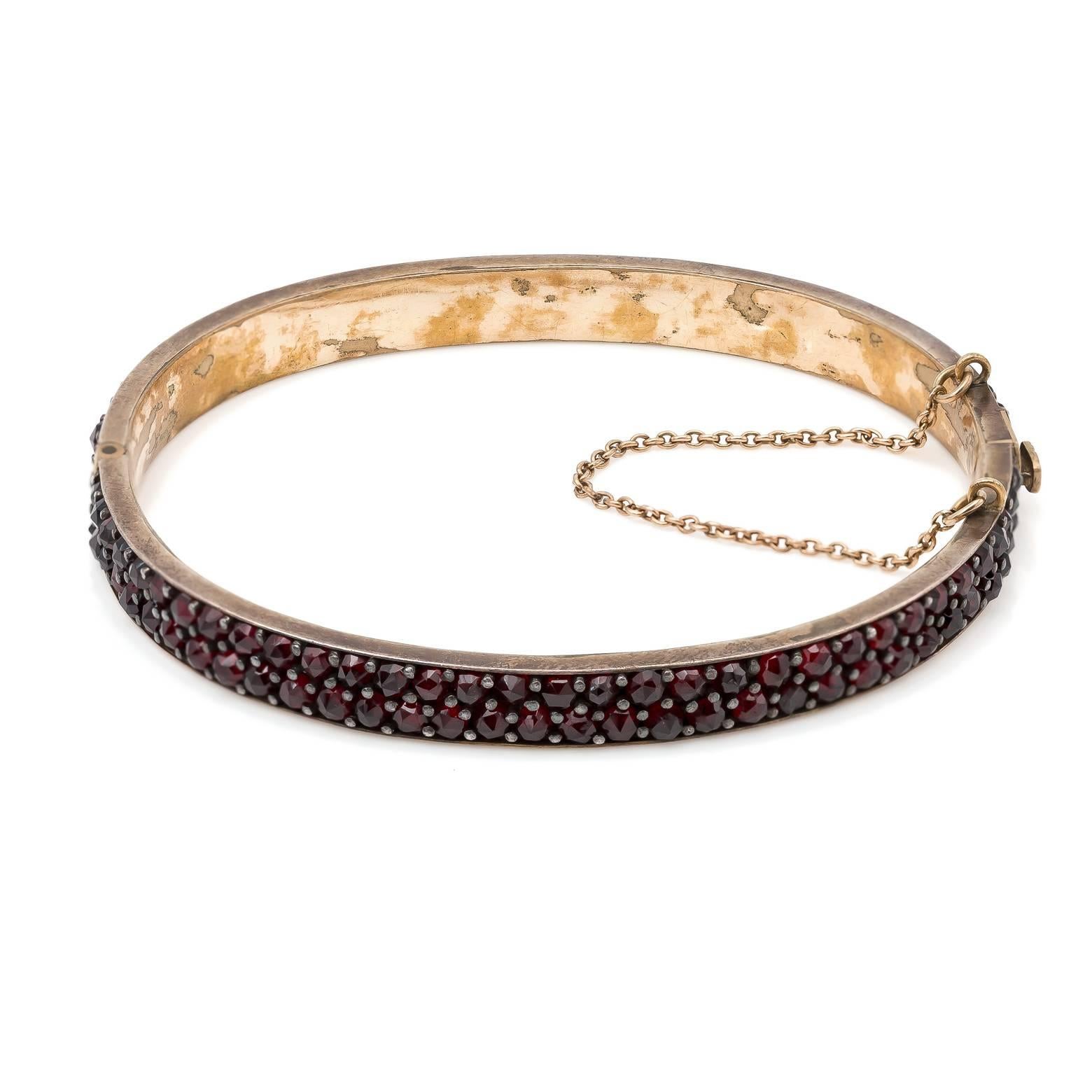  This garnet bangle was hand crafted in the 1880's and the workmanship is flawless. The garnets are perfectly matched in color and clarity. The comfort is exceptional as well.. The shape of the bangle is oval and has a very secure clasp and safety