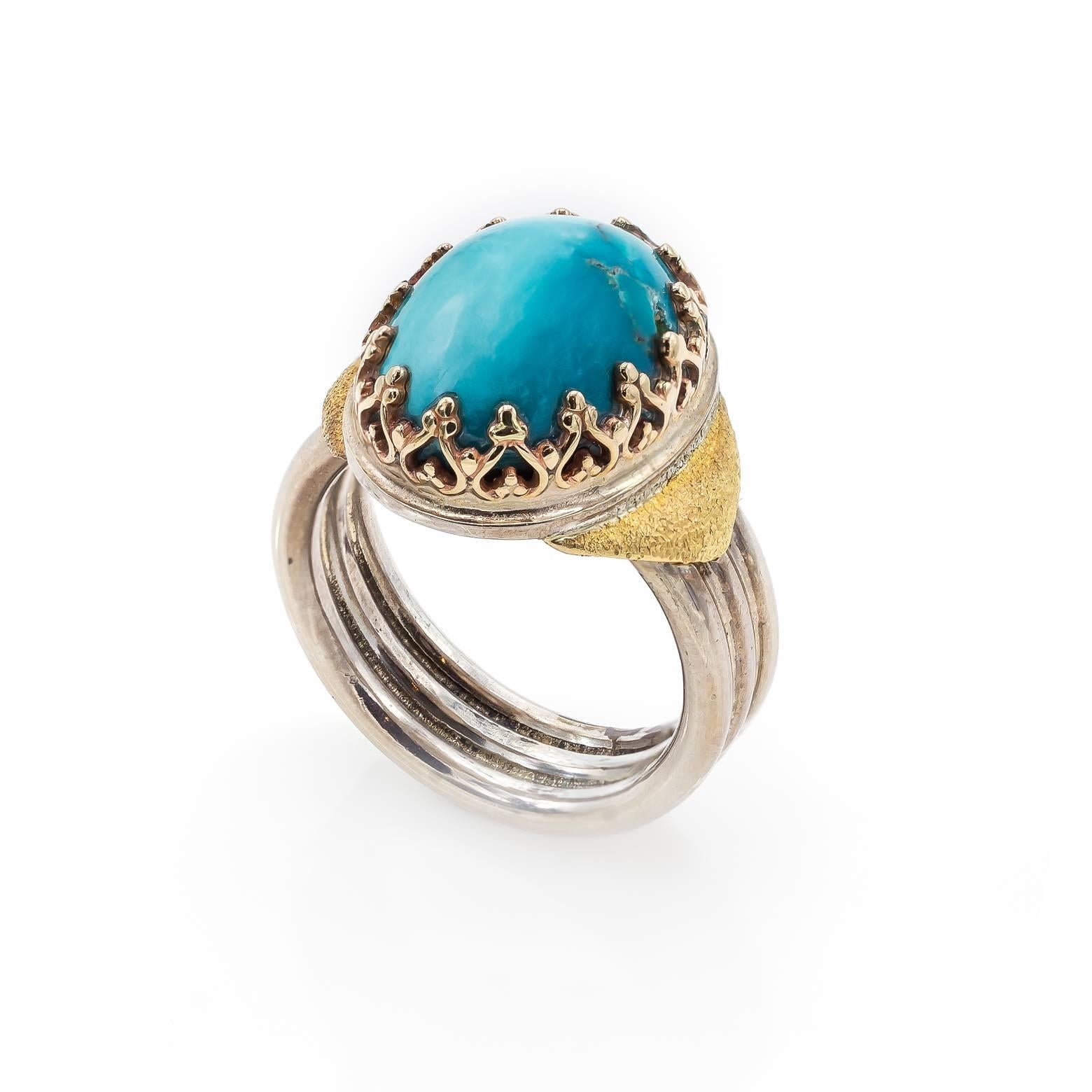 This large sky blue oval turquoise cabochon ring is decorated with a lace-like 14K yellow gold bezel and a three ridge sterling silver band. A substantial piece with many shades of turquoise ranging from ethereal to deep Caribbean Blue. 