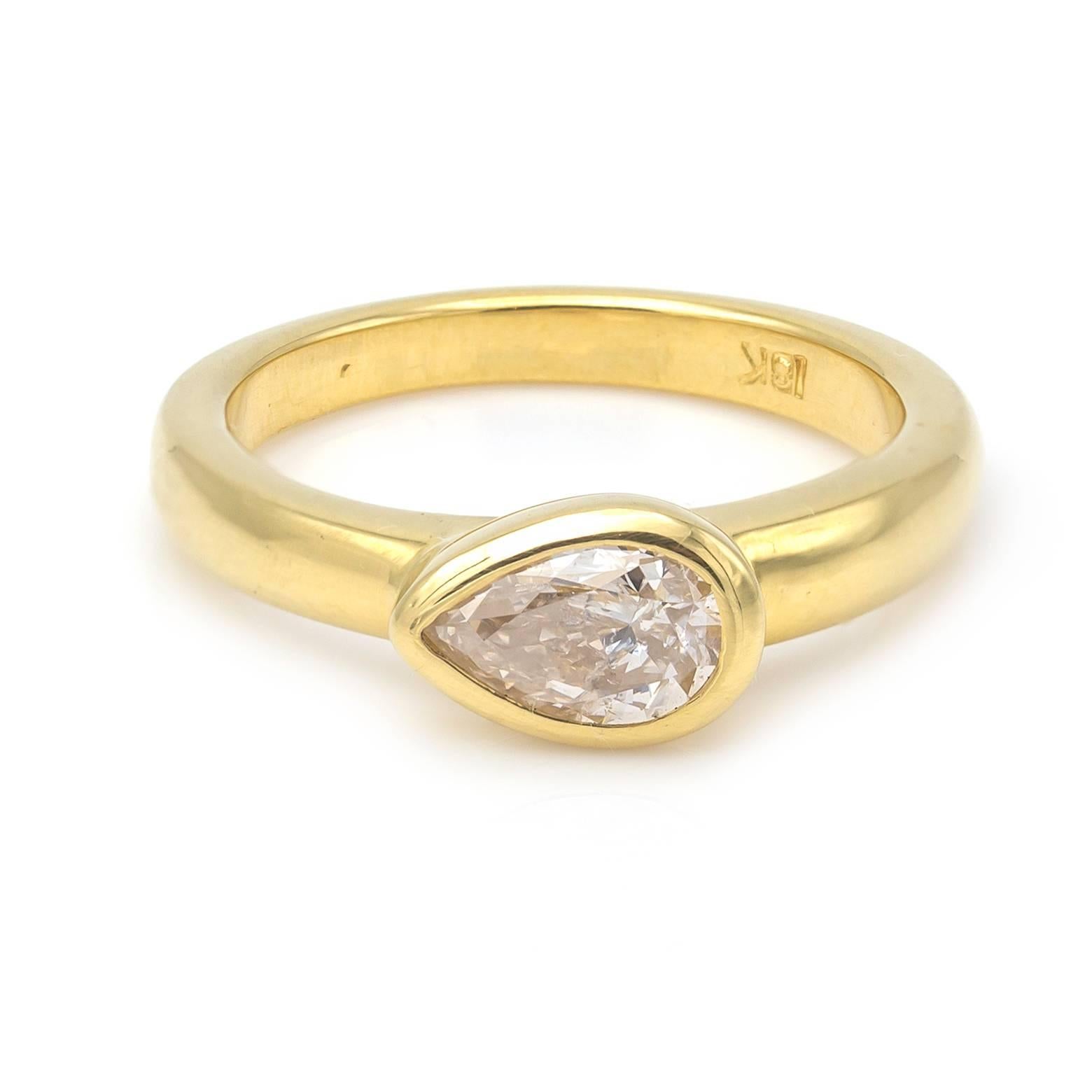 This stunning and classic diamond ring is set in 18K yellow gold and the diamond size is approx. 0.62 carats. The side setting of the tear drop diamond is elegant and artistic as it sings of individuality and is made to perfection in a traditional