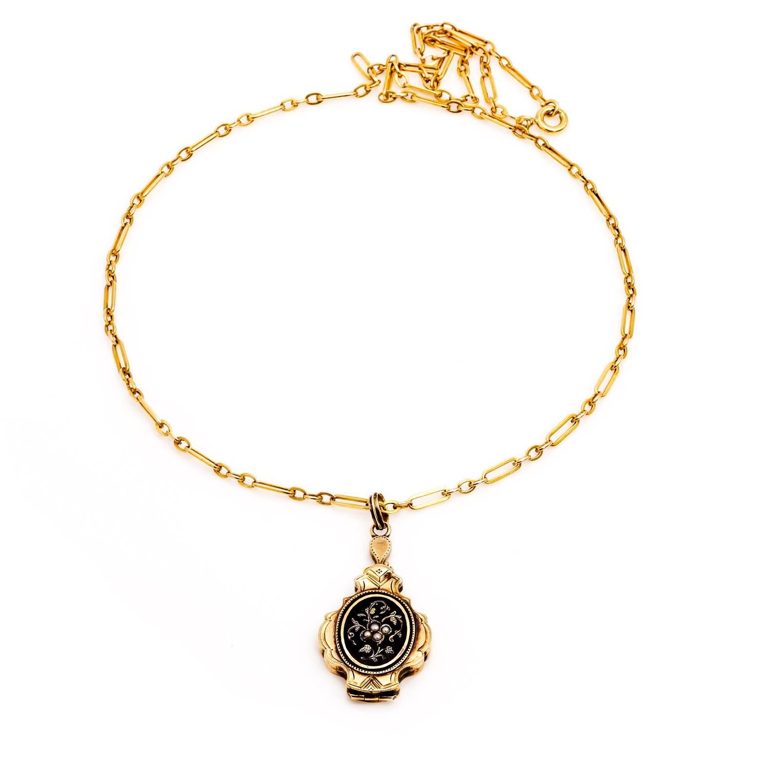 This intricate and unique locket is decorated in black enamel, fresh water pearls and engraved in gold. The antique locket opens up top to bottom giving it an exceptional quality that sings of greatness. In excellent condition and absolutely