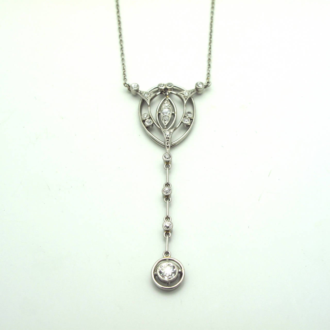 This stunning Art Deco necklace is a wonderful collector's item in that it is beautifully designed with a cascade of diamonds suspended from an inlayed 'orbit'. The diamonds are G/H color and VS2-SI1 quality.This necklace is truly unique.