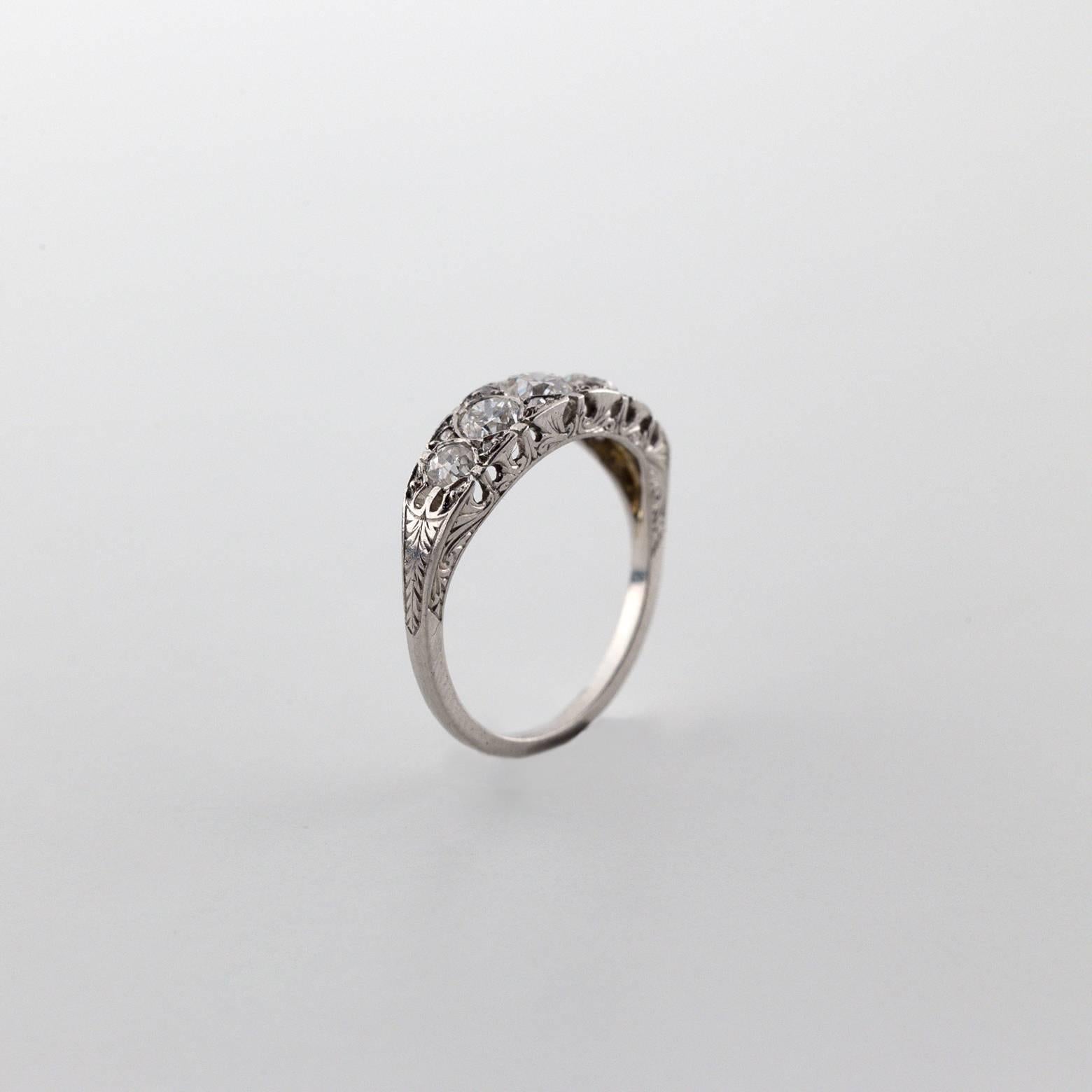 Antique 5 Diamond Ring with rose cut Diamond accents. The detail work on this ring is absolutely stunning and the intricate detailed design on the sides almost looks feather-like. It's a signature piece from the 1920's and the platinum brightly