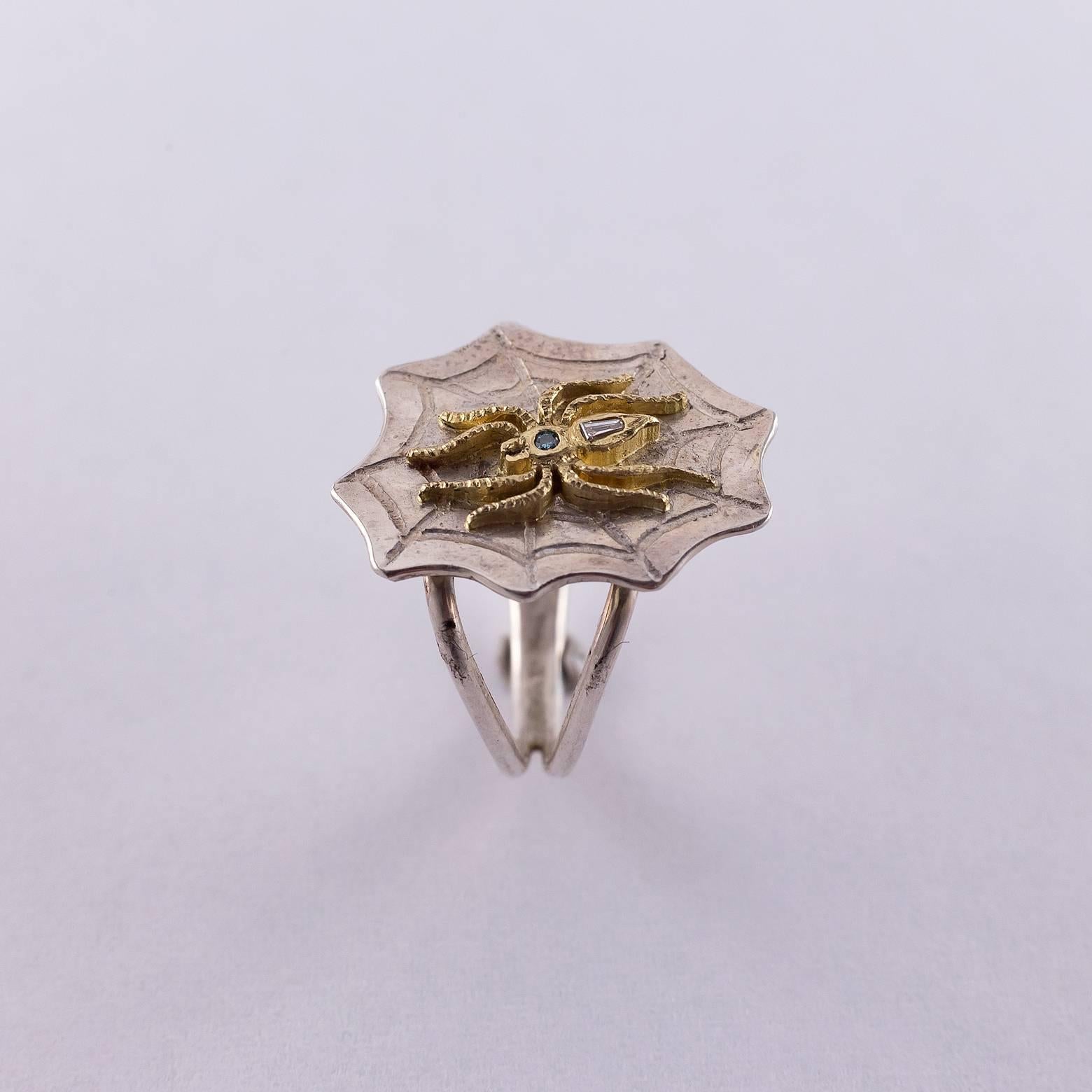 This bright and haunting piece comes with 1 blue diamond and 1 baguette diamond, 14K Yellow Gold and Sterling Silver. The intricacy on this spider is beautiful and the combination of diamonds gives it a unique glow. Size 6.75