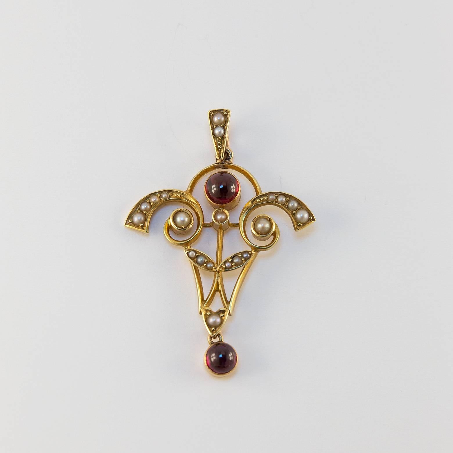 Gorgeous Art Nouveau Garnet and Pearl Pendant! This antique pendant is a unique 15K Yellow gold and glimmers with 20 pearls and 2 warm garnets. It's in excellent condition and is a great time-piece! Chain sold 
