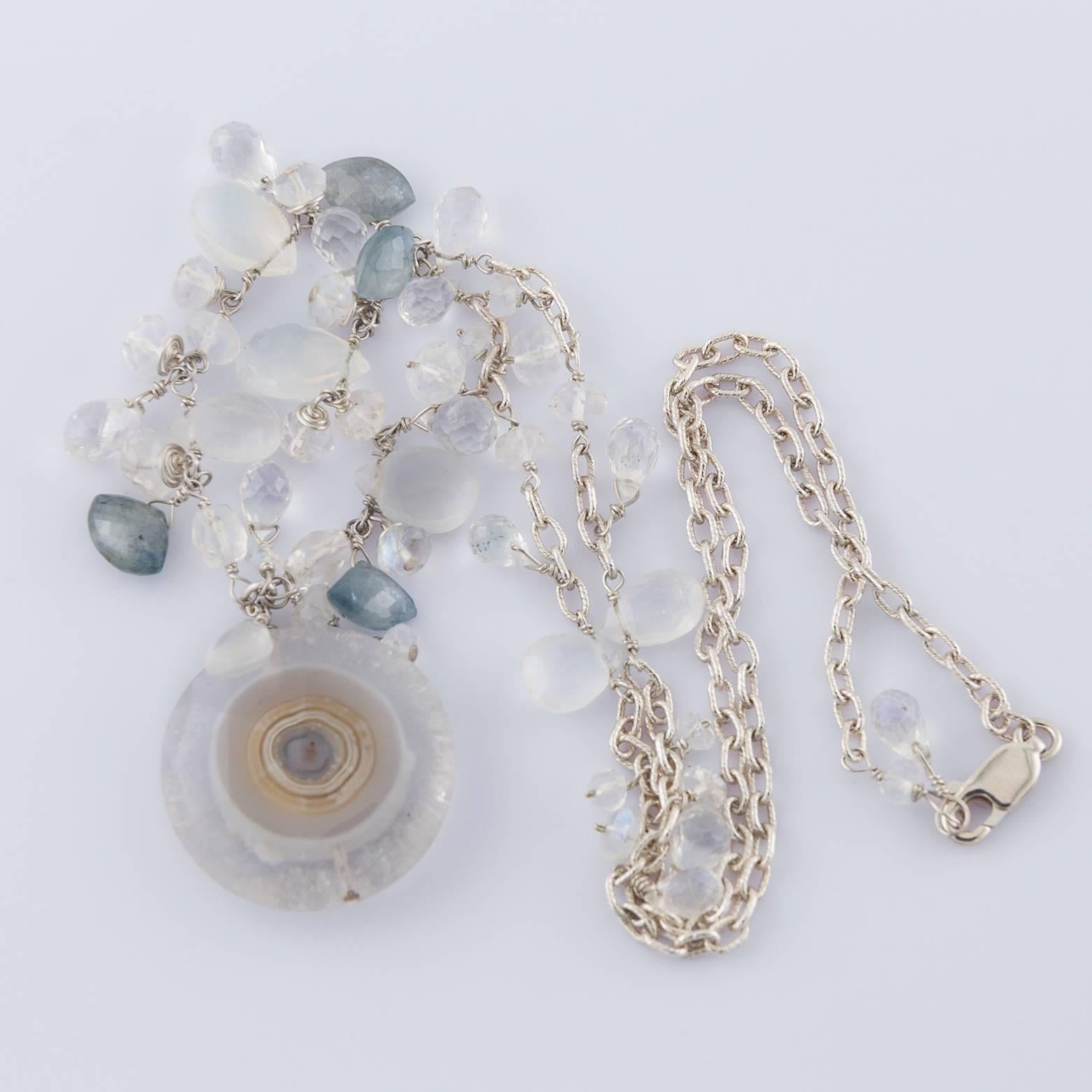 Moonstone, Labradorite and a slice of a stalactite embellish this gorgeous necklace with unique flare. Lightweight given it's 7/8 in. diameter, it's elegant and earthy and on Sterling Silver. The light blues and whites of the moonstone glam it up