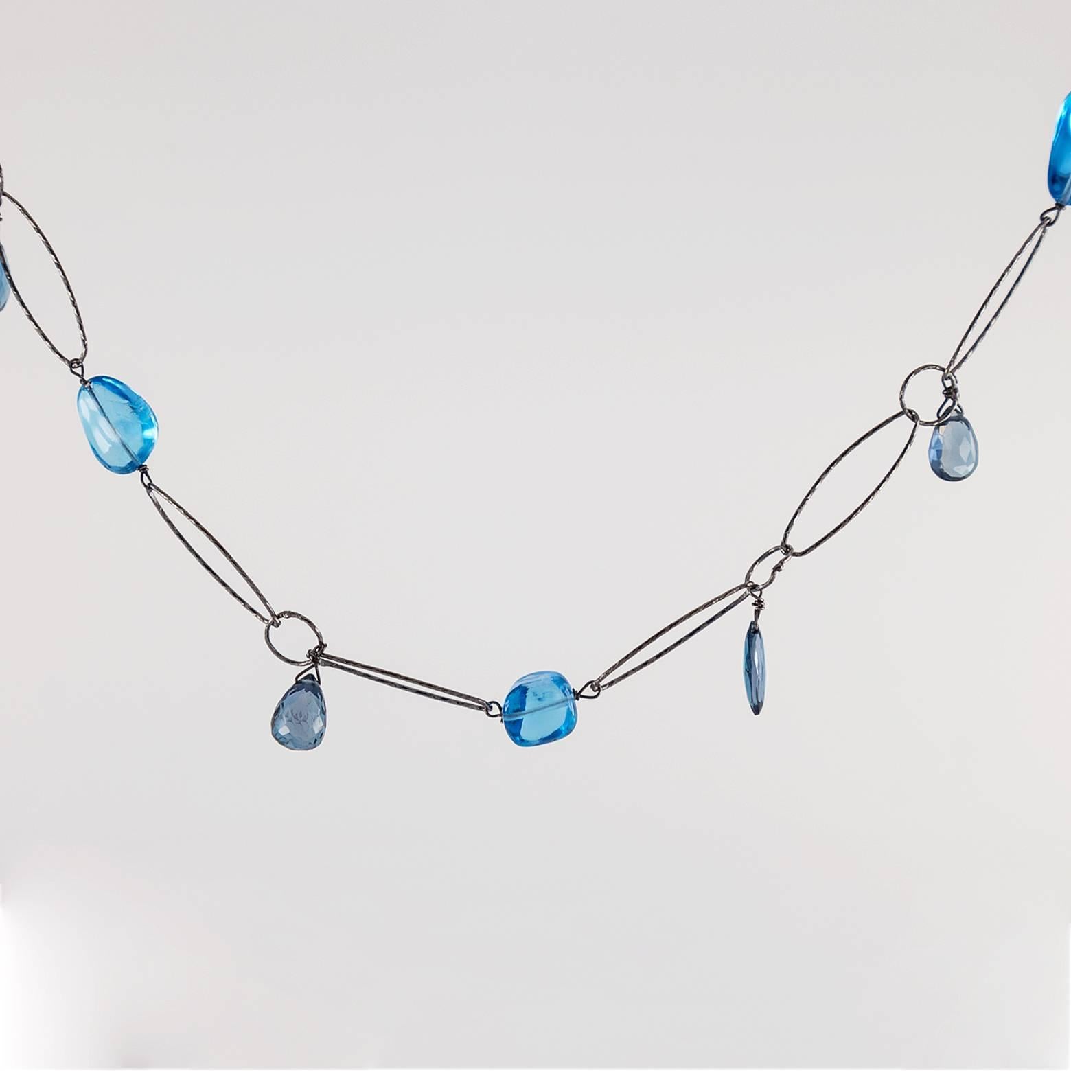 Long and sophisticated tanzanite and kyanite blues and purples ranging in size and hue on an oxidized hammered chain link. With deep ocean blues crossing the distance to light refracting in the atmospheric clouds, this elemental necklace reaches