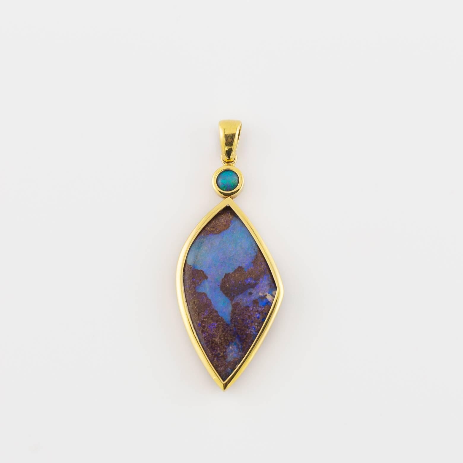 This stunning pendant is electrifying with sparkling blues and greens that seem  out of this world. This beautiful butterfly wing-like Boulder Opal dazzles, sparkles, and enchants it's viewers. A stunning pendant set in 18K Yellow Gold. 
