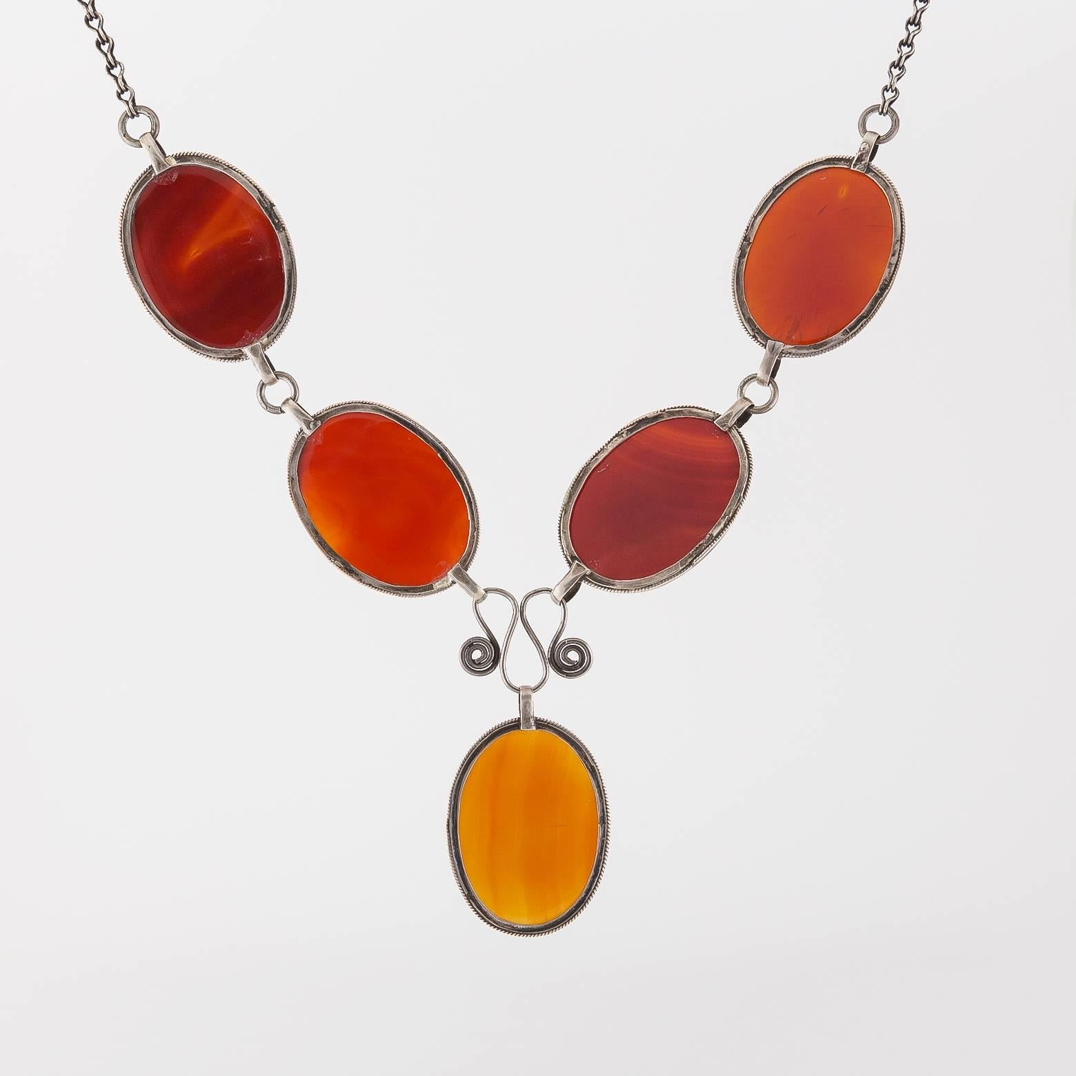 This unique statement piece is made of 5 large and gorgeous carnelian pieces that range in different colors and gradients from dark brick to red-orange. They provide a brilliant entertaining glow that fascinates the wearer with a substantial weight