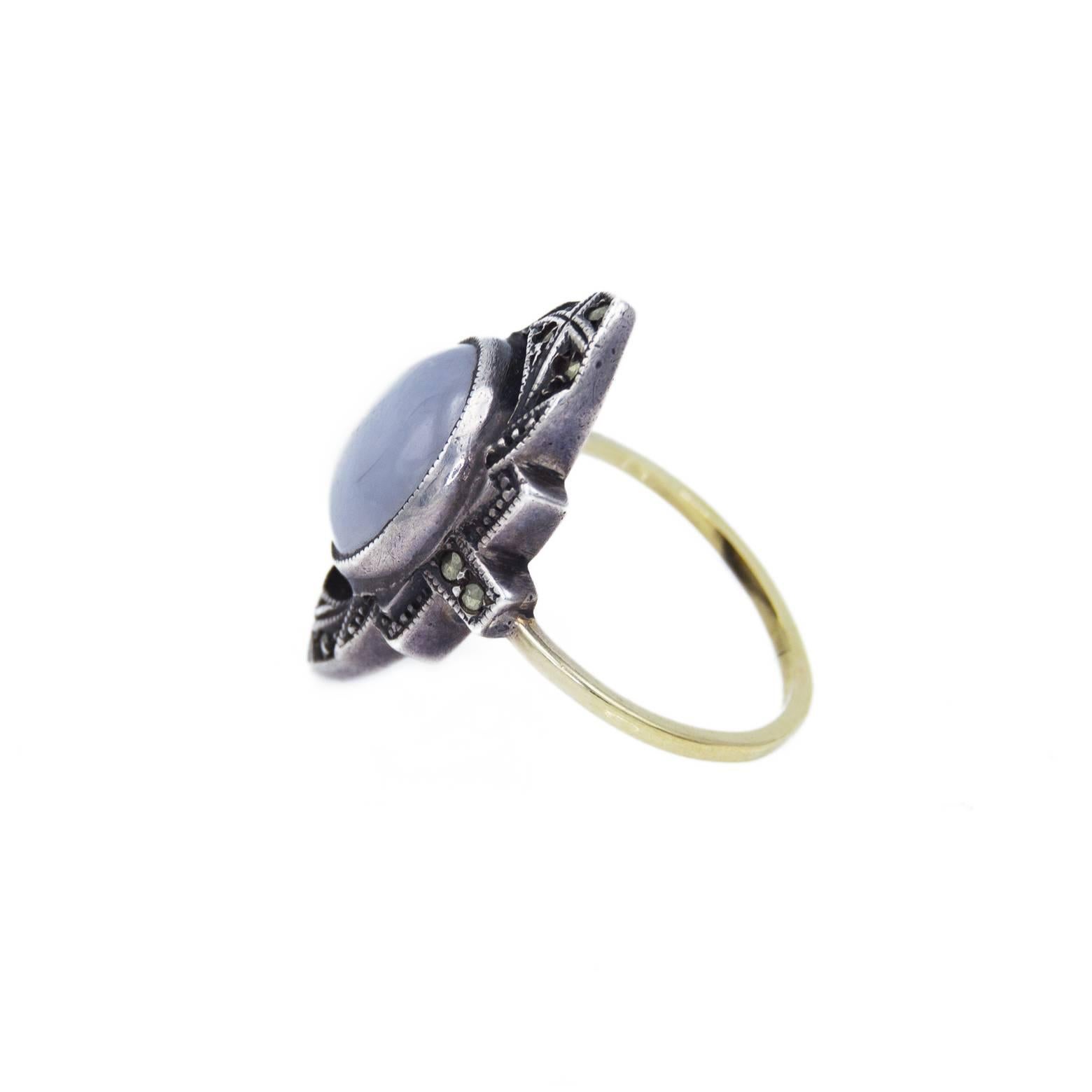 This stunning Art Deco ring is a 'sparkler' with the beautiful star sapphire surrounded by marcasite. The detail is geometric in design and compliments the round sapphire. The ring is a 5 1/4.