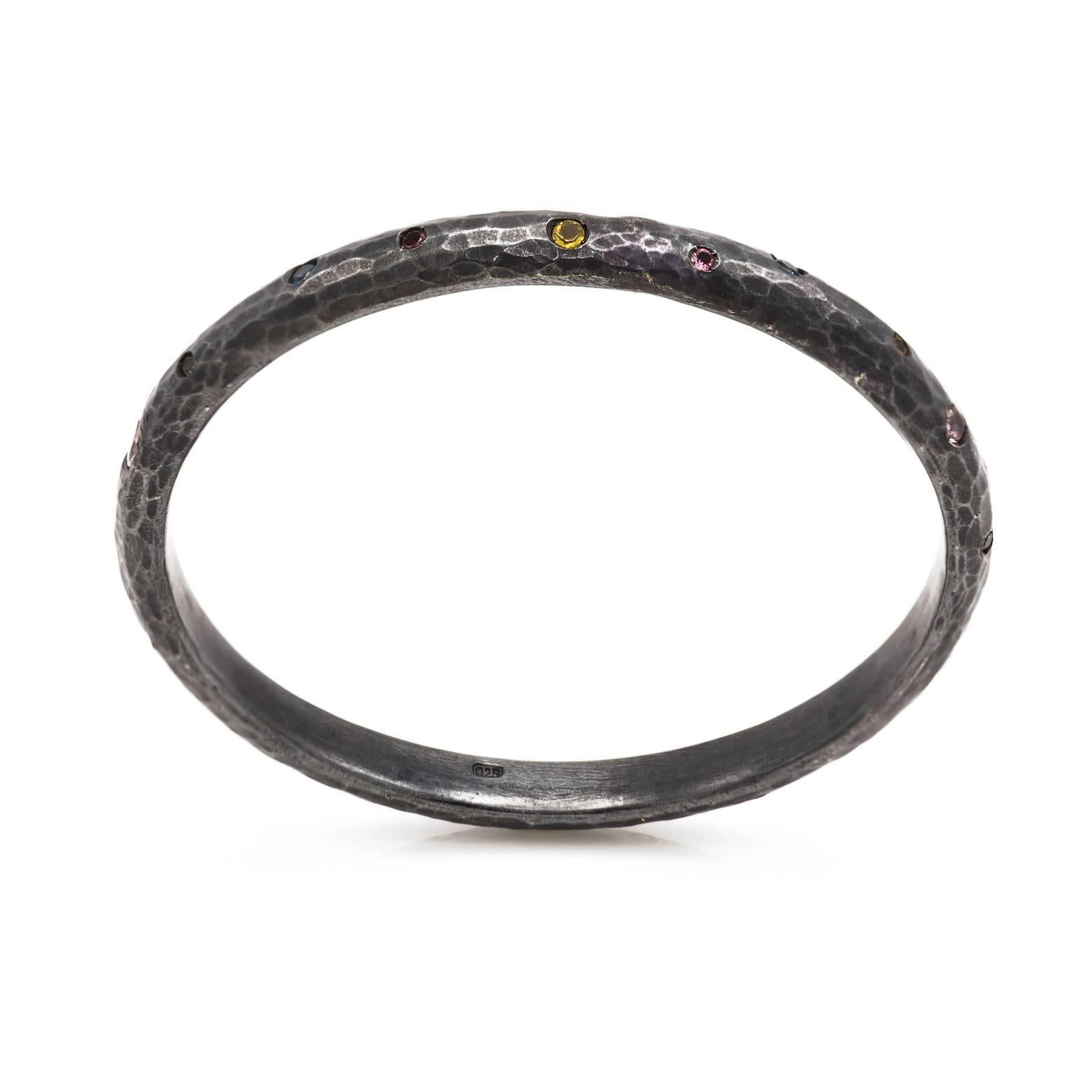 This strong and sturdy bangle is hammered and has hidden jewels like sparkling candies decorated throughout. The beautiful bright colors of the tourmaline, citrine and topaz bring light and life to the contrasting dark hammered boldness of the