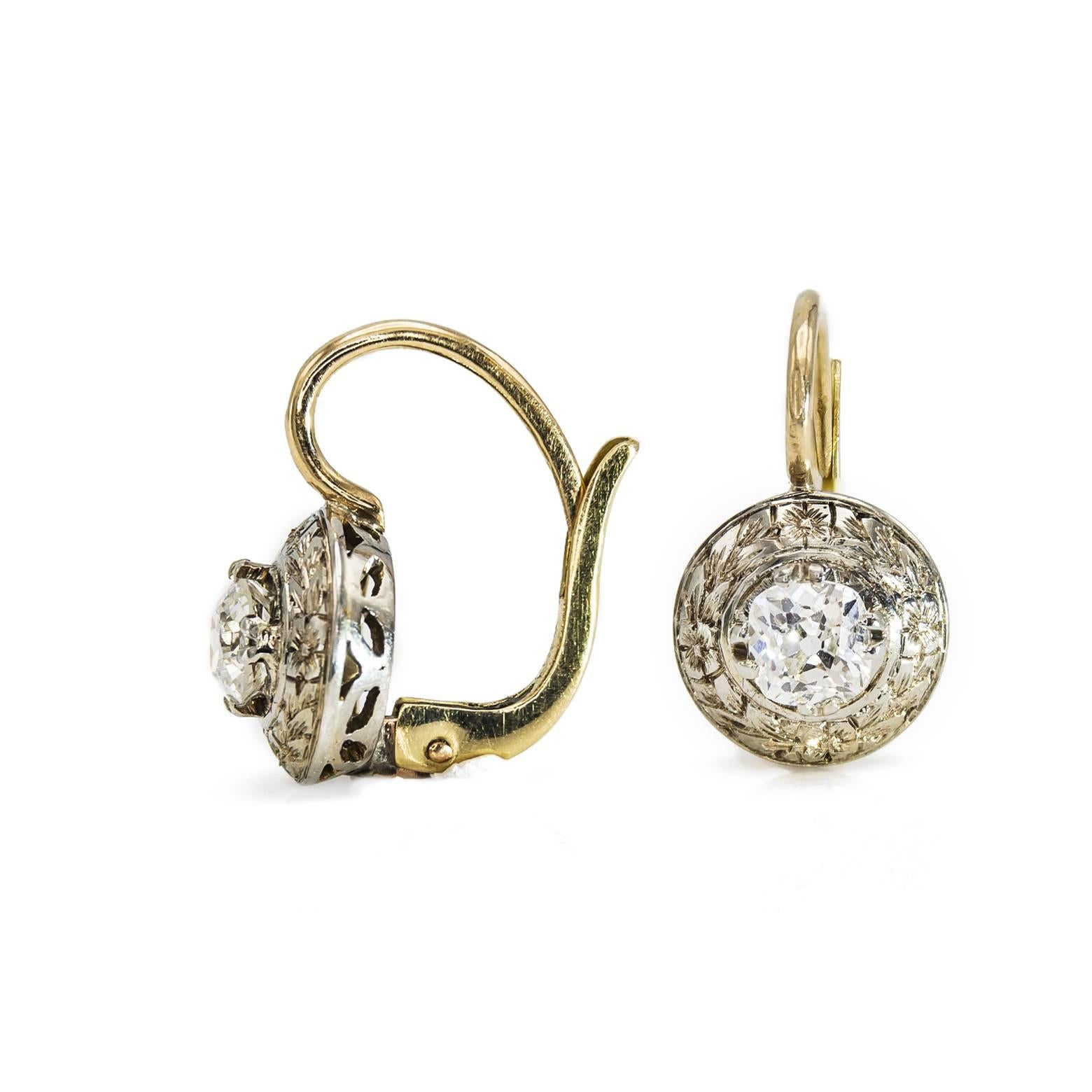These beautiful antique round old mine-cut diamond earrings have a gorgeous floral halo around the center diamond. Engraved in white gold these gorgeous diamond earrings tell stories of a romantic time and place in Italy among the fountains and