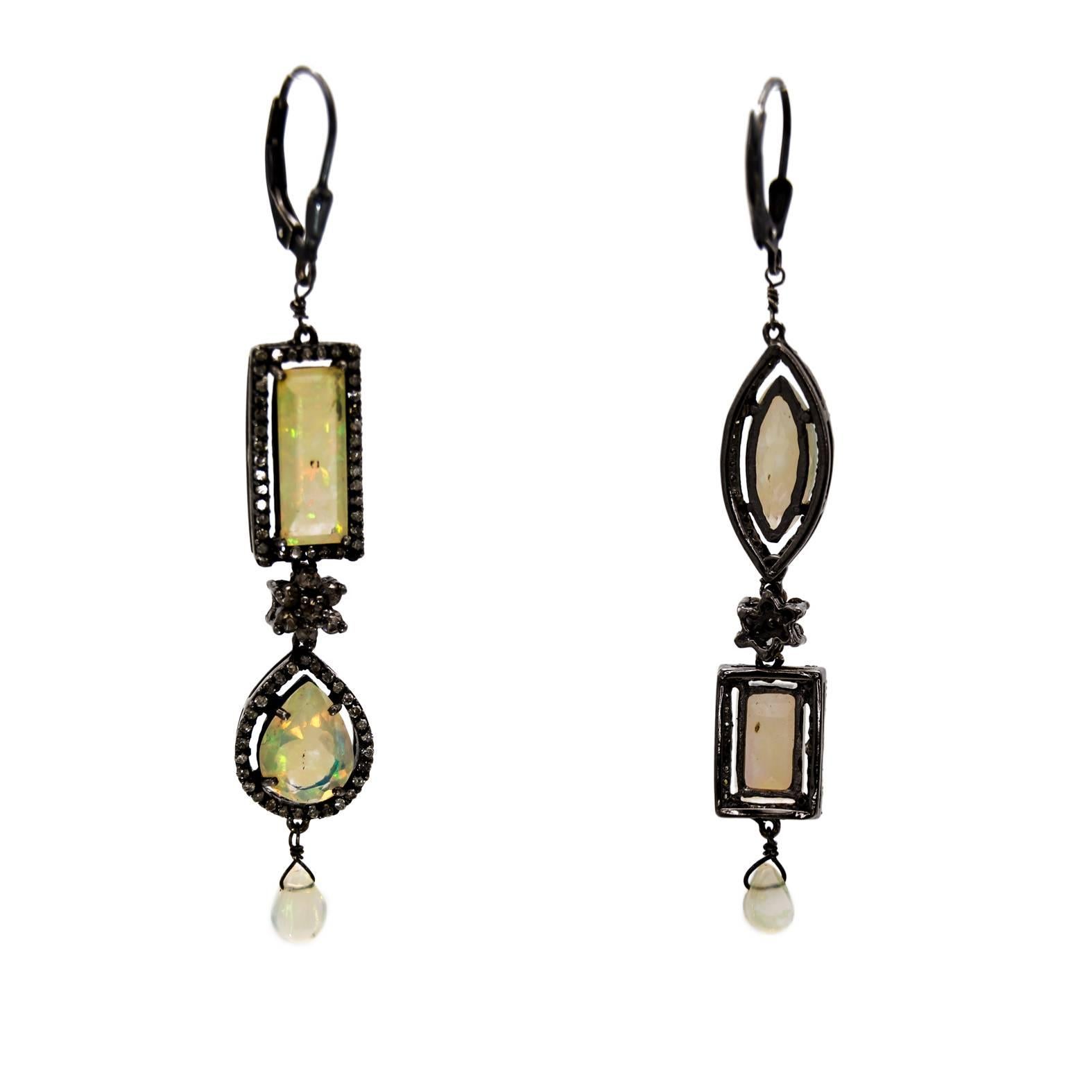 Beautiful architectural dangling earrings decorated with dazzling opals and surrounded in diamonds. These oxidized sterling silver earrings have emerald cut opals, marquise opals, and opal briolettes. The oxidized sterling silver enhances the glow