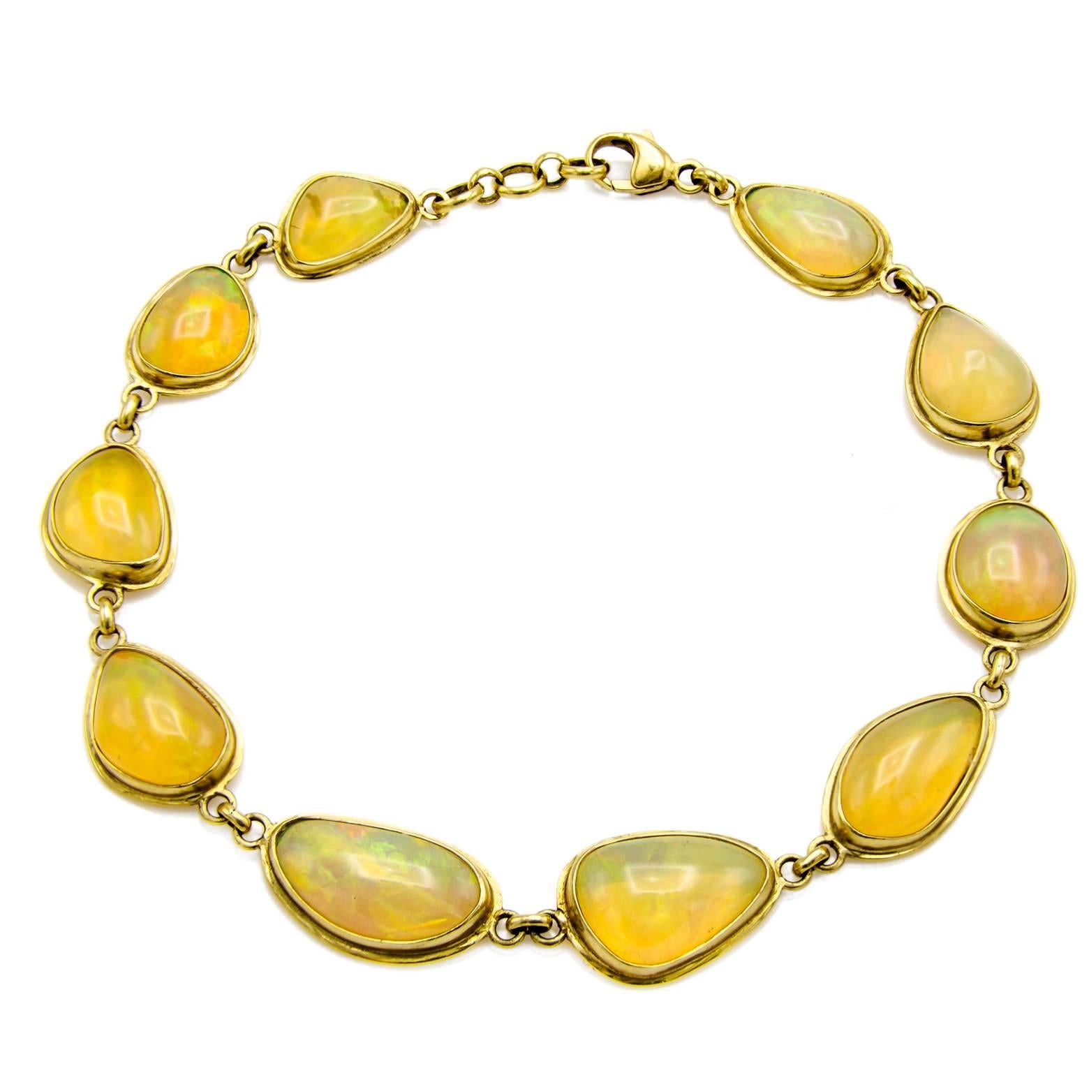 10 large stunning opals make up this 18K gold bracelet. In many different shapes and sizes with an opalescence that is almost impossible to capture on camera this magical opal bracelet brings elegance to a whole new level. Golds, fiery reds and