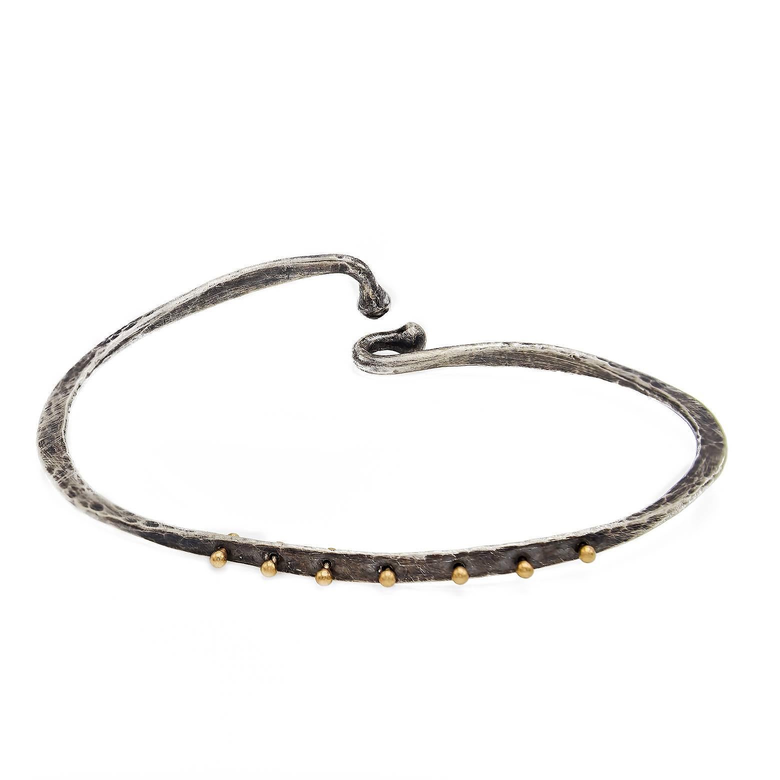 This hammered bangle is urban and 'Hip'.The 14k gold 'rivets' enhances  the oxidized finish. The 'lock' closure is secure and artfully done. A classic yet unique piece of jewelry. 