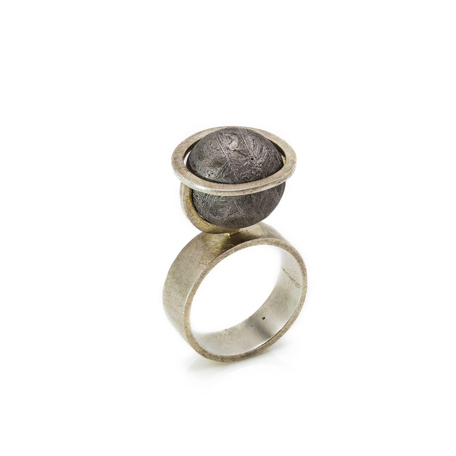 It's a literally out of this world meteorite ring with amazing patterns in this one of a kind sphere. An architecturally brilliant design completely unique in jewelry fashion. A strong and sturdy sterling silver ring with a bold lead-like grey