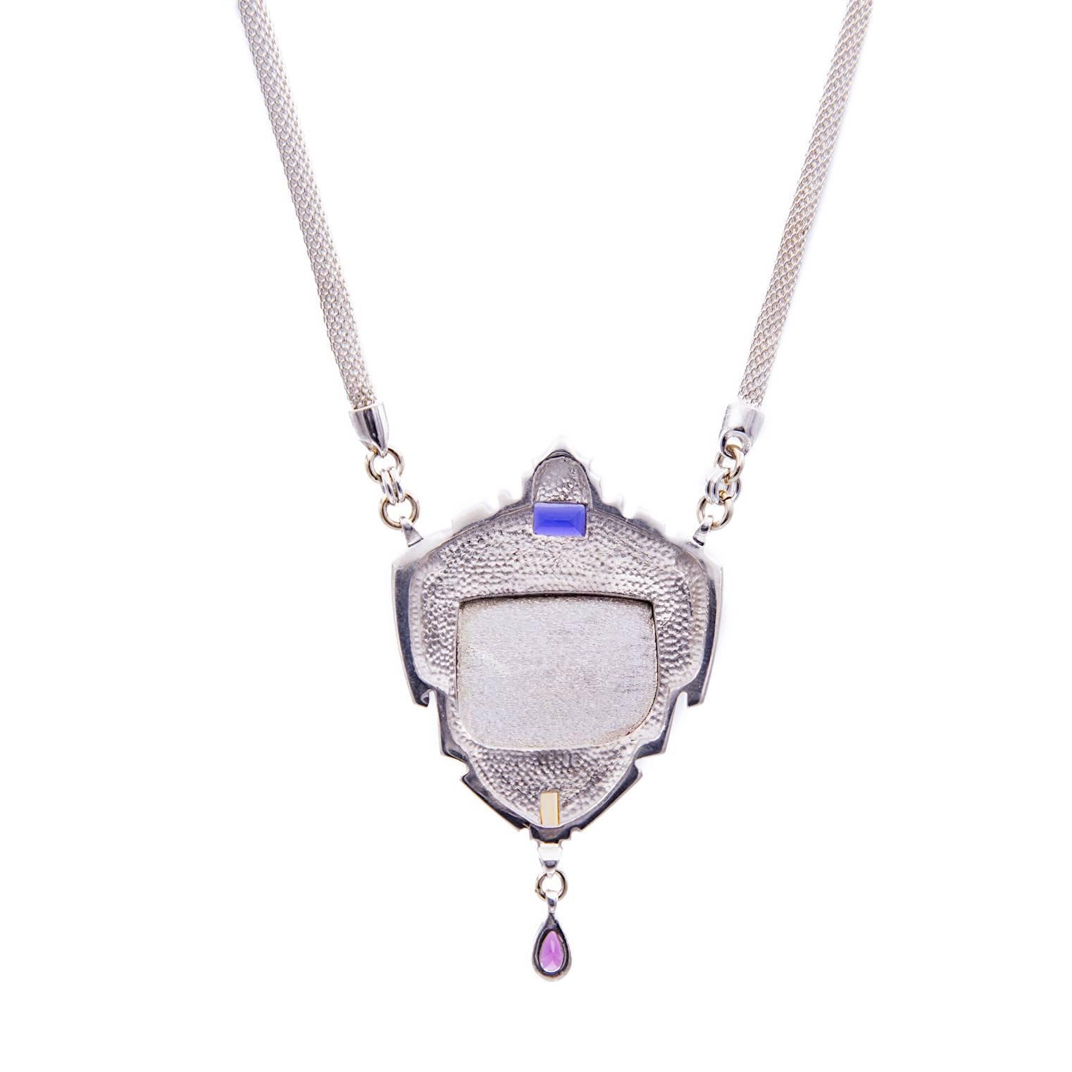 A brilliant artistic creation! The beautiful central jasper looks as if it's a scene from the southwest with spiraling skies and iron-rich plains. Set in a crown of sterling silver this piece is adorned with a deep blue iolite on top and a tear-drop