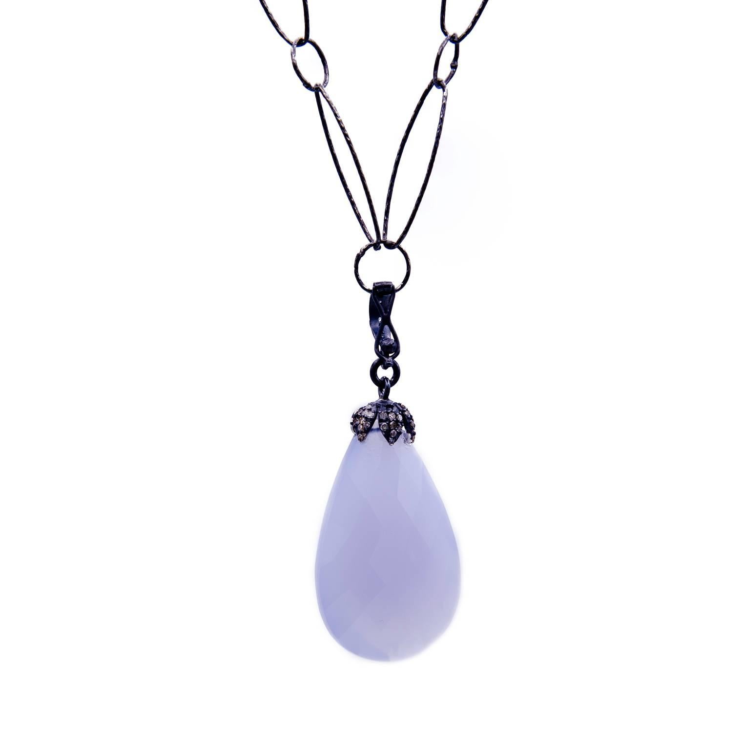 This beautiful chalcadony drop is suspended by a diamond encrusted cap and detachable bale. The light blue milky color of the stone is complimented by the oxidized accents and chain. A perfect neutral to wear often day and night!