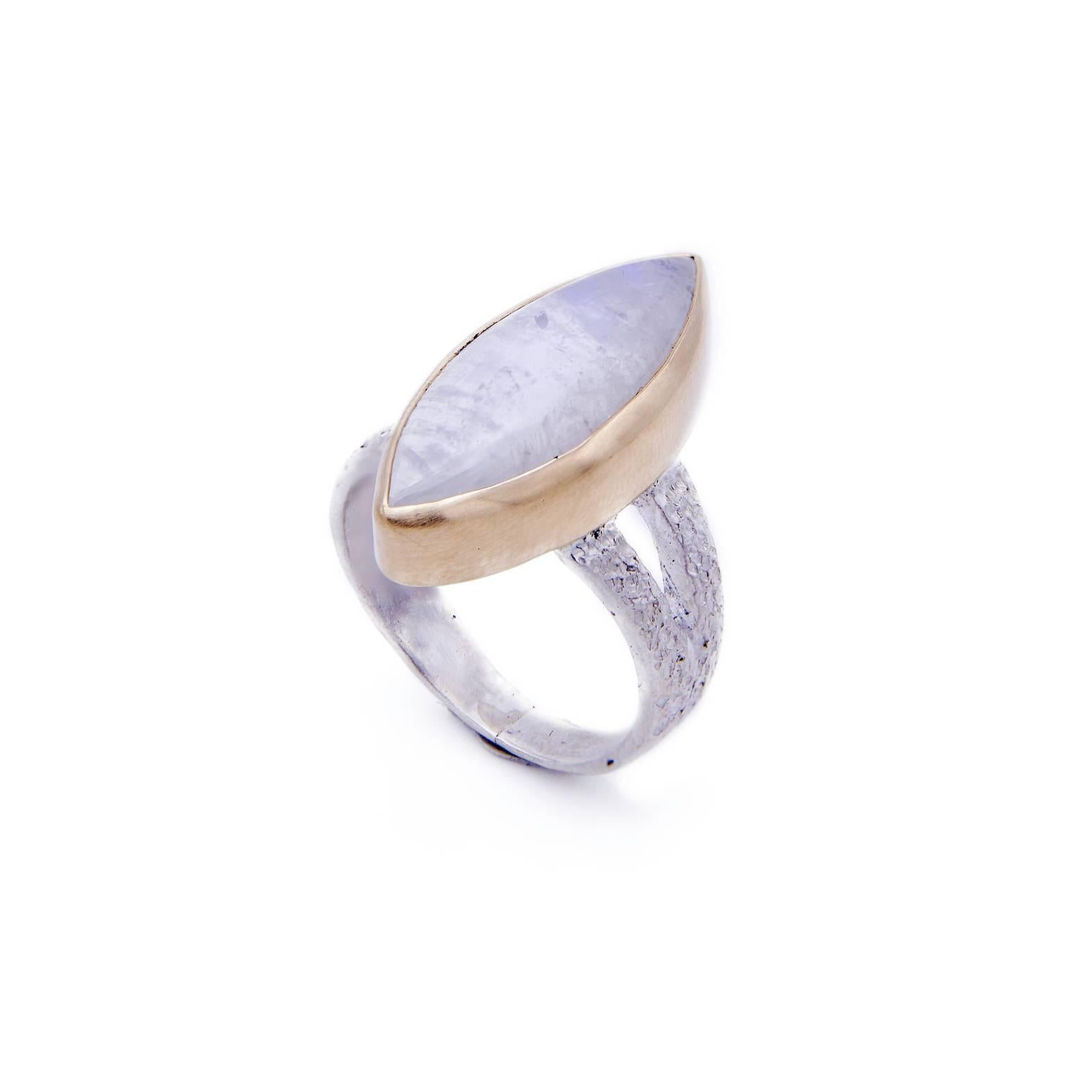A gorgeous marquise moonstone statement ring with an elegant bluish-purple sheen. The satin finish gold bezel is complimented by a textured white sterling silver band that is perfectly hammered and hand detailed. It was made by our resident designer