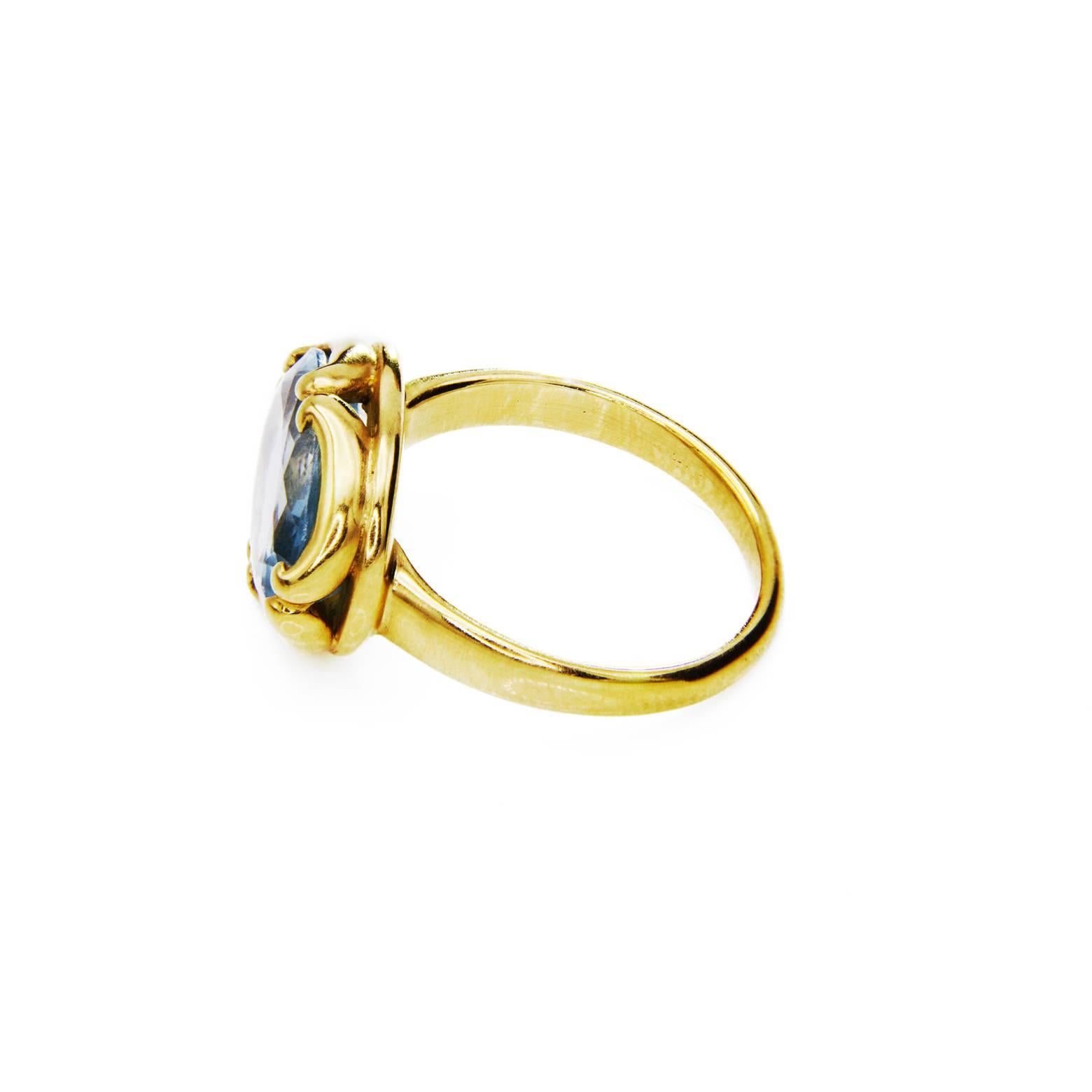 An aquamarine as brilliant as the clear blue sky. It's a large oval faceted stone set in a gorgeous 18K gold ring Byzantine Style gold ring. The design is fantastical and looks as if a  brilliant stone is set in a delicate crown.
Aquamarine oval