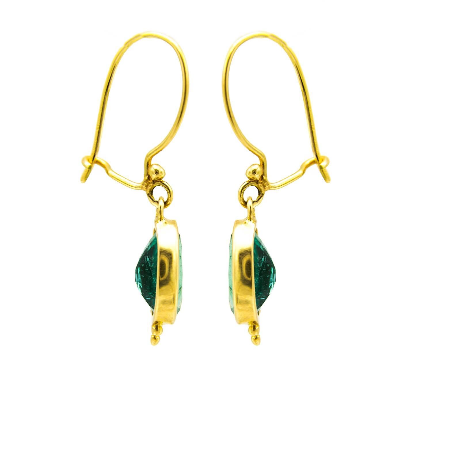 These gorgeous green oval old mine cut emerald green earrings are dainty and delightful. A substantial weight (3.9 carats total). The 18K yellow gold wire compliments these beauties while the sparkly green emeralds glow. 