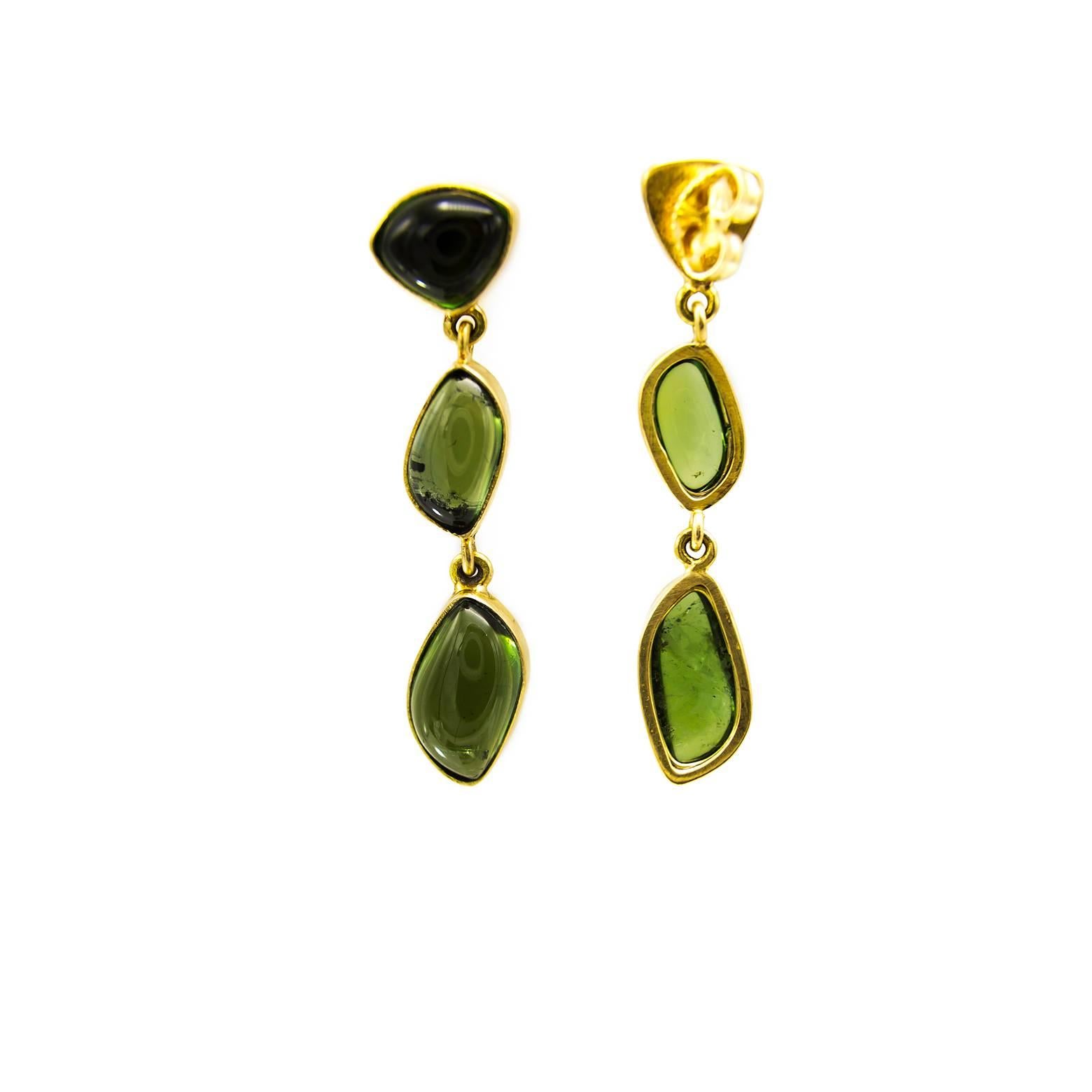 Three different charming cabachons of beautiful spring green tourmalines dangle down in 18K yellow gold. With a substantial weight and a swaying movement these earrings are sure to add a festive flare to any outfit. 