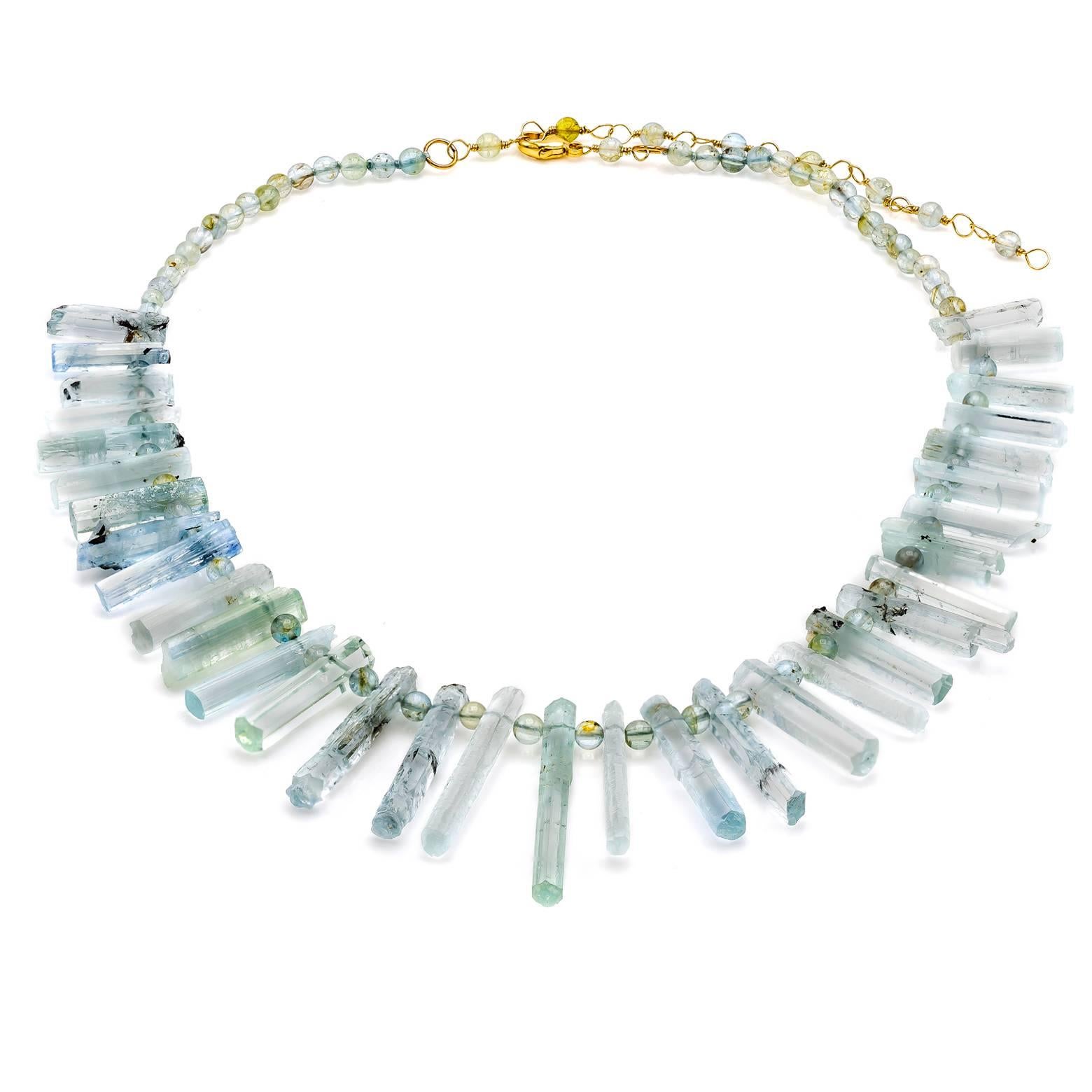 A beautiful natural aquamarine necklace that tapers in length as is adorned with round beads that compliment the raw uncut style of the long hexagonal spears. Delicate hues of light blue and teal in this aquamarine necklace sparkle as the natural