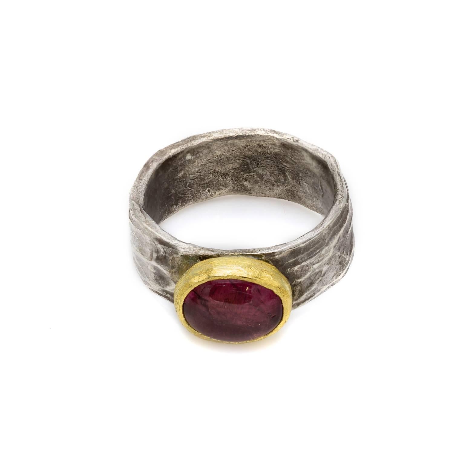 Gorgeous and Artistic! This one of kind ring is fun and unique as the textures of the metal are hammered in a wave-like fashion creating a beautiful contrast to the soft pink tourmaline cabochon. 14K yellow gold is set around the centerpiece adding