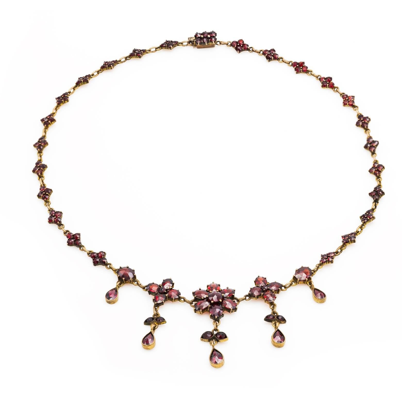 Garnets galore in this beautiful turn of the century necklace in the classic Victorian style. Stunningly brilliant garnets with a floral design in the center create a masterpiece that you'll want to stare at every day. Rich, delicious, fire cinnamon