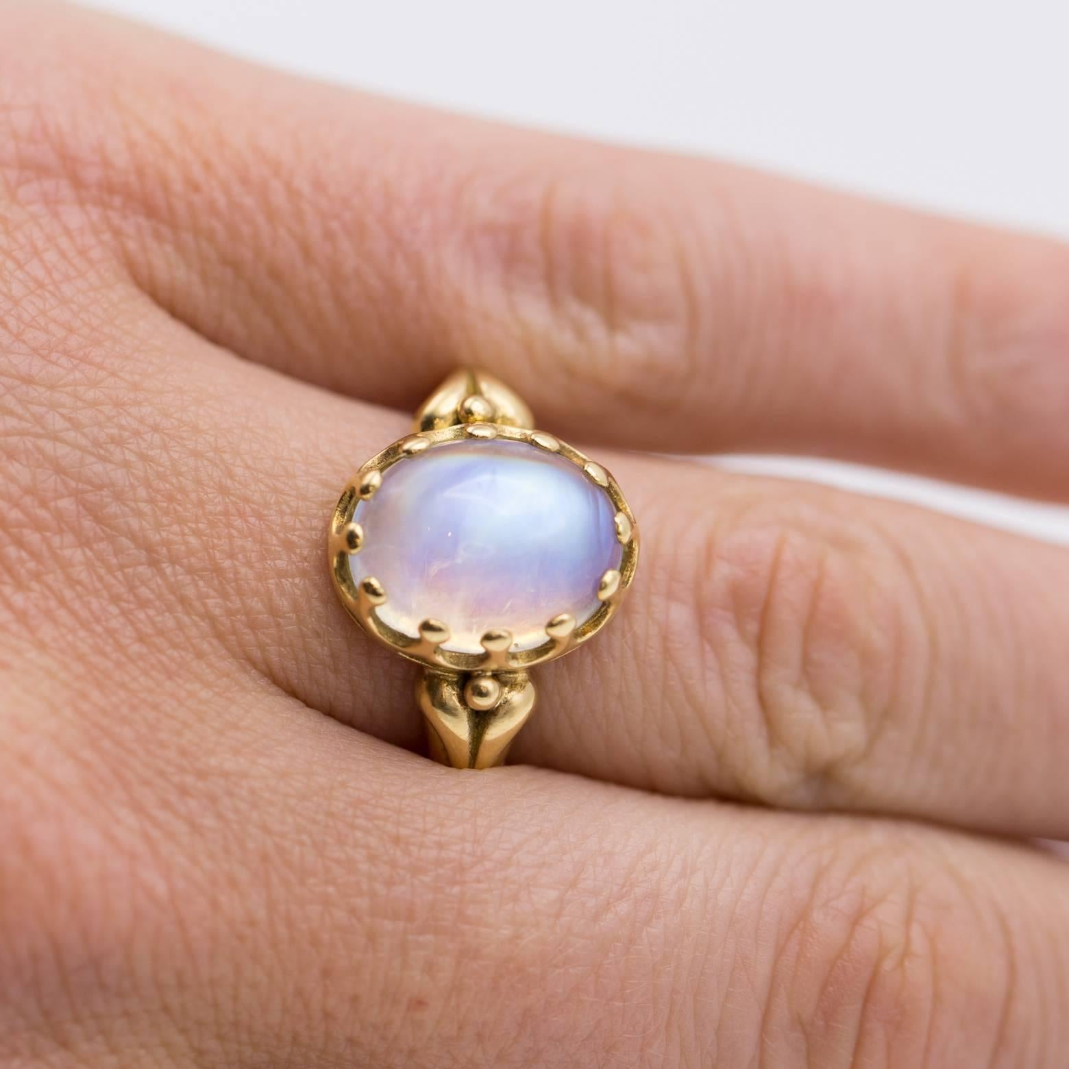 This artistic and gorgeous ring has an incredible bezel and gorgeous band. The oval moonstone has beautiful horizontal inclusions that create bright rainbow colors that are mesmerizing. Set in 18K yellow gold this ring sings with beauty. 