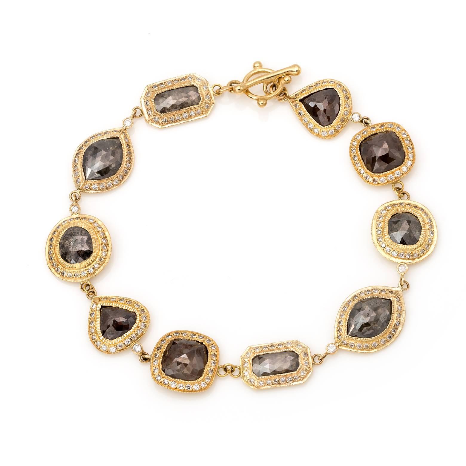 Champagne and brown diamonds surrounded with a white diamond bezel in 10 gorgeous links set in 14K Yellow gold. Each diamond could be a center piece in itself as this bracelet showcases 5 different shapes from marquise, circle, square, drop and