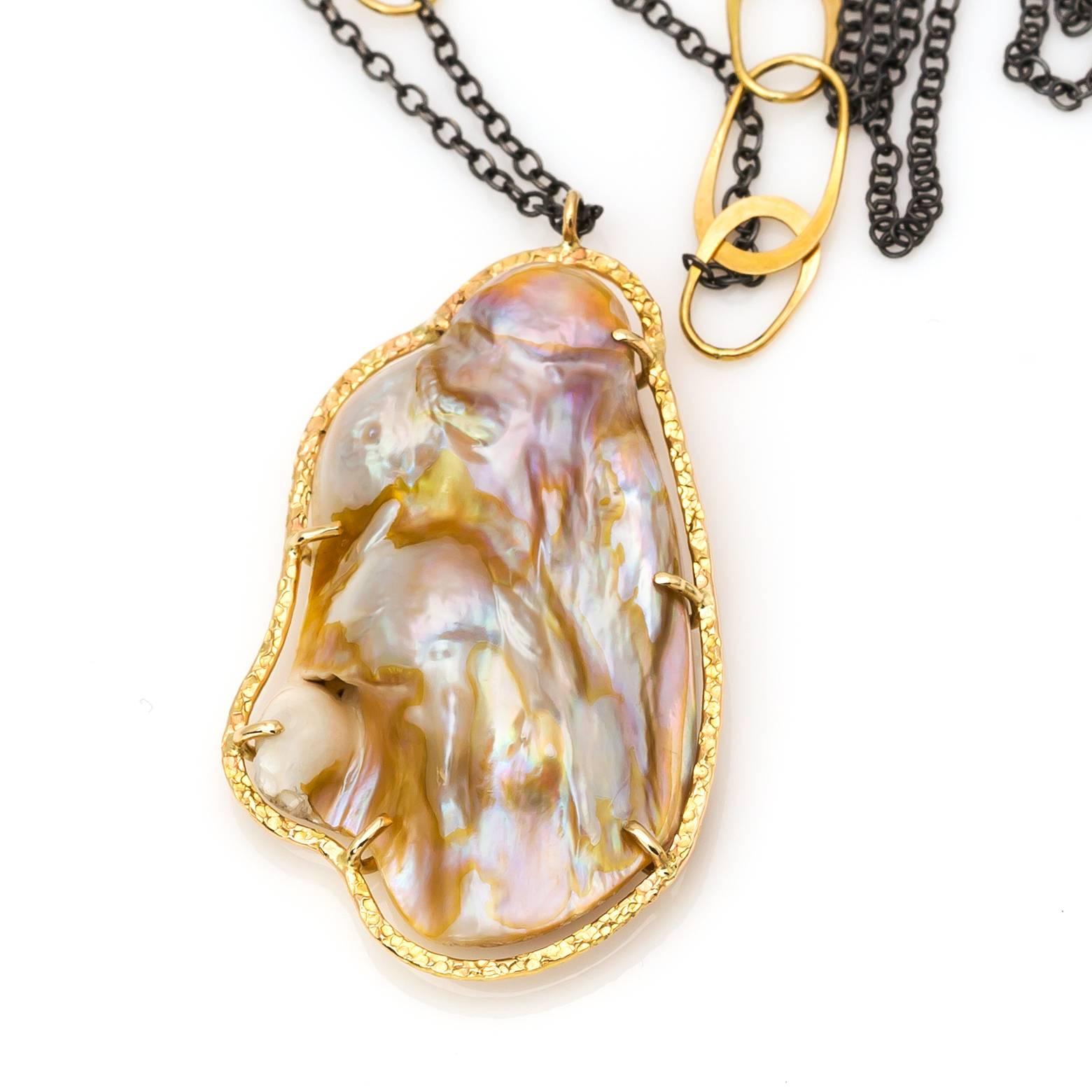 This organic shaped fresh water pearl glows in whites, pinks, and corals and is set in a beautiful hammered 14K yellow gold bezel. Hangs from a 32 inch oxidized sterling silver chain. Stunning and substantial!