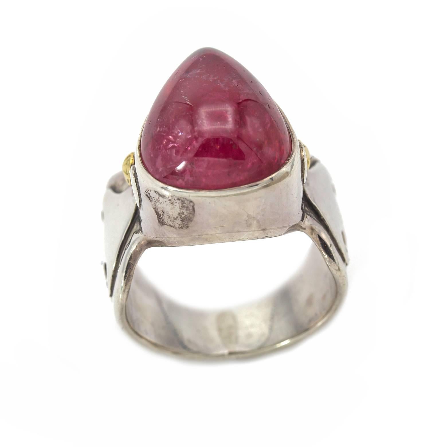 This large raspberry/watermelon pink tourmaline ring is substantial and regal! Fire-like dragon spirals add an artistic flare to the thick wide band that tapers toward the back. Sterling Silver with 18K yellow gold accents. Size 6.5