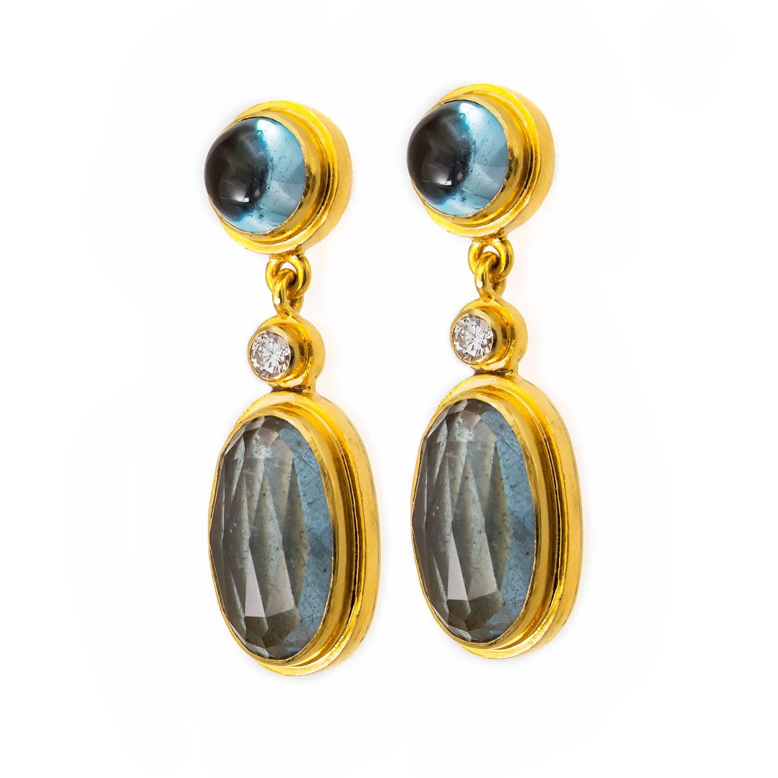 These beautiful, glamorous drop earrings are elegant and earthy set in 18K yellow gold with white diamond accents, blue tourmaline, and oval faceted moss aquamarines. Calming watery earth tones with bright yellow gold compliment these beauties
