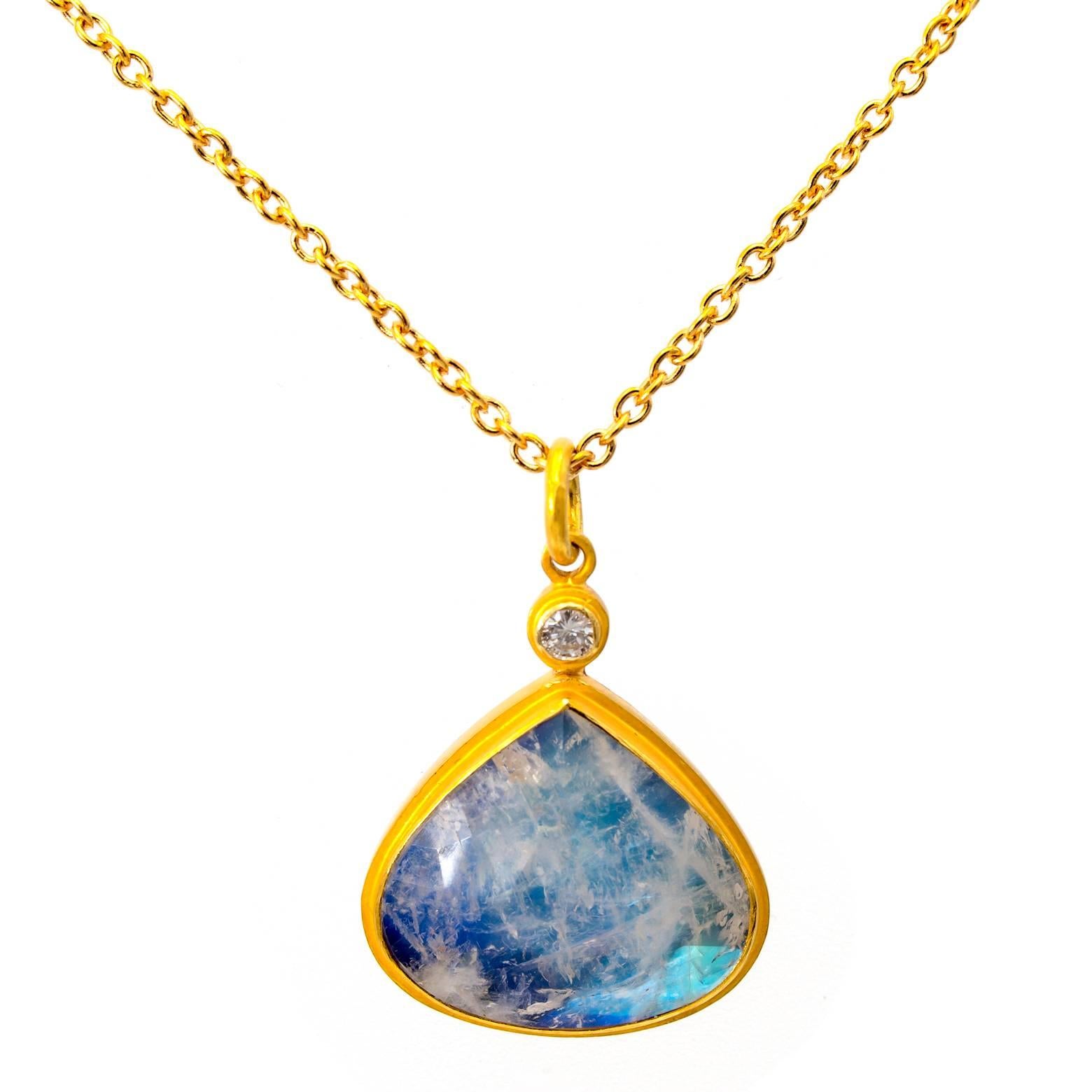 White swirls of cloud-like moonstone dance around a backdrop of bright iridescent blue creating a pendant masterpiece. Rainbow moonstone is a shiny blue color with icy white inclusions that reflect and refract light in many directions. This piece is