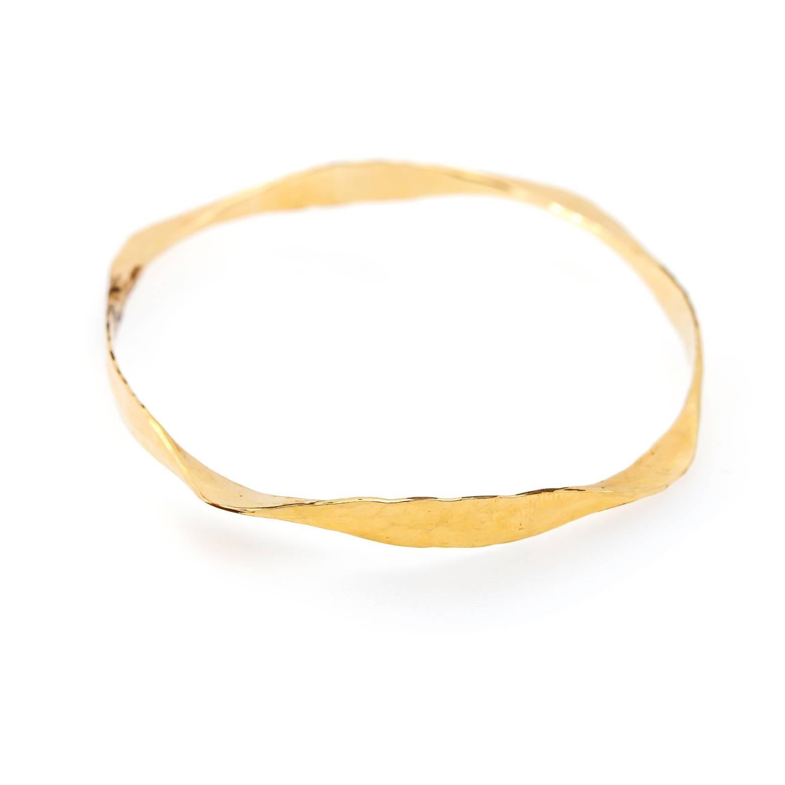 This twisted hammered hand made beauty is a gorgeous bangle with an artistic flare.The hammered detail reflects light and shines bright is yellow gold. Made in our studio in the San Francisco Bay Area. 14K Yellow Gold