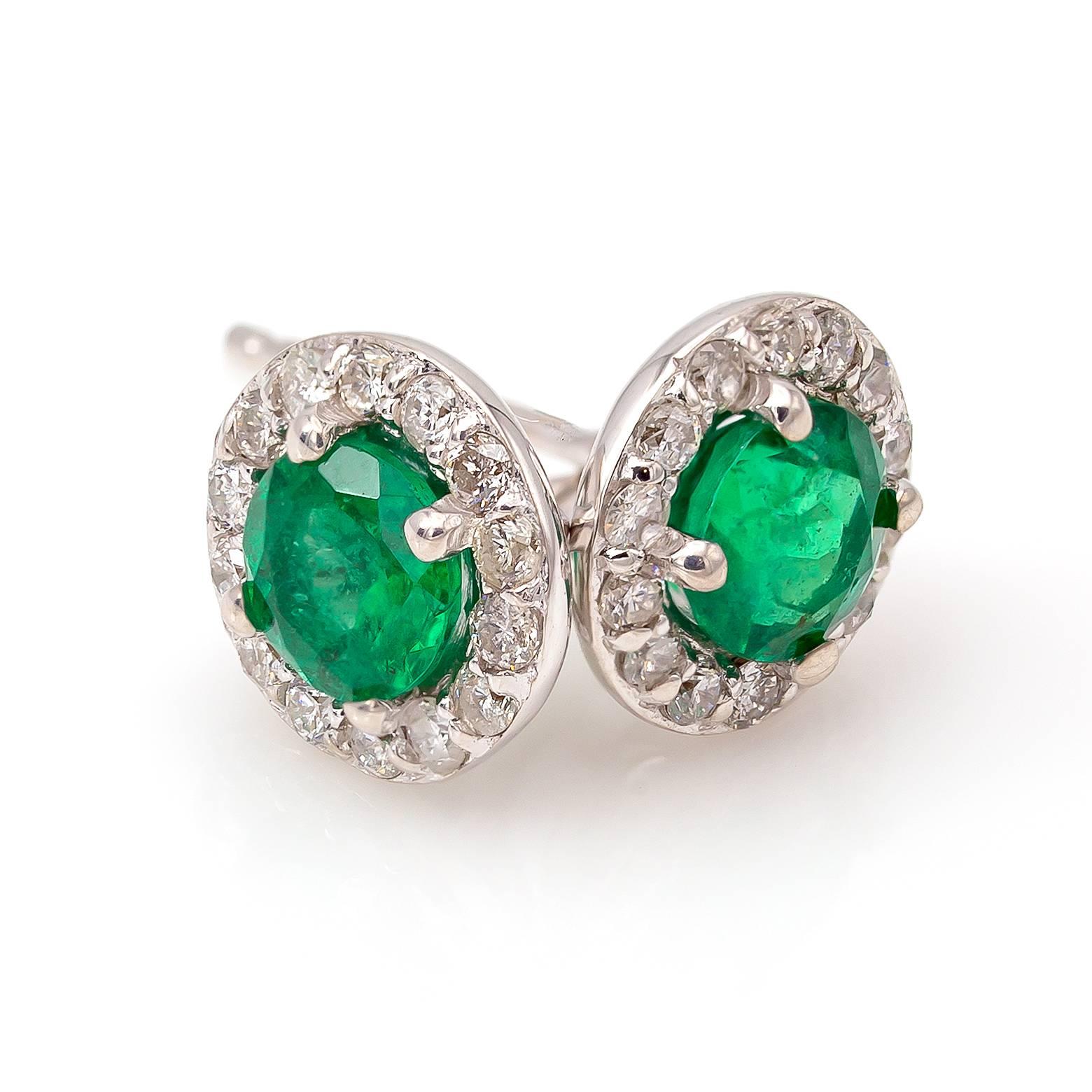 Bright sea green emeralds surrounded with a diamond halo bring an elegant twist to a classic look. A yummy soft green in the most sophisticated of fashion. These beauties equal 0.88 carats in the total weight of both emeralds and 0.26 carats of